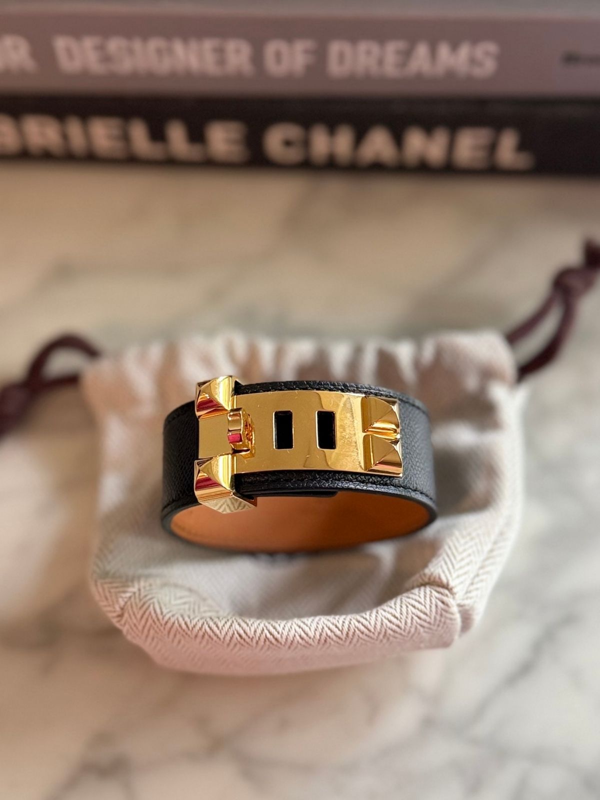 Louise Row featuring Hermes Collier Cuff 24 in black leather on table