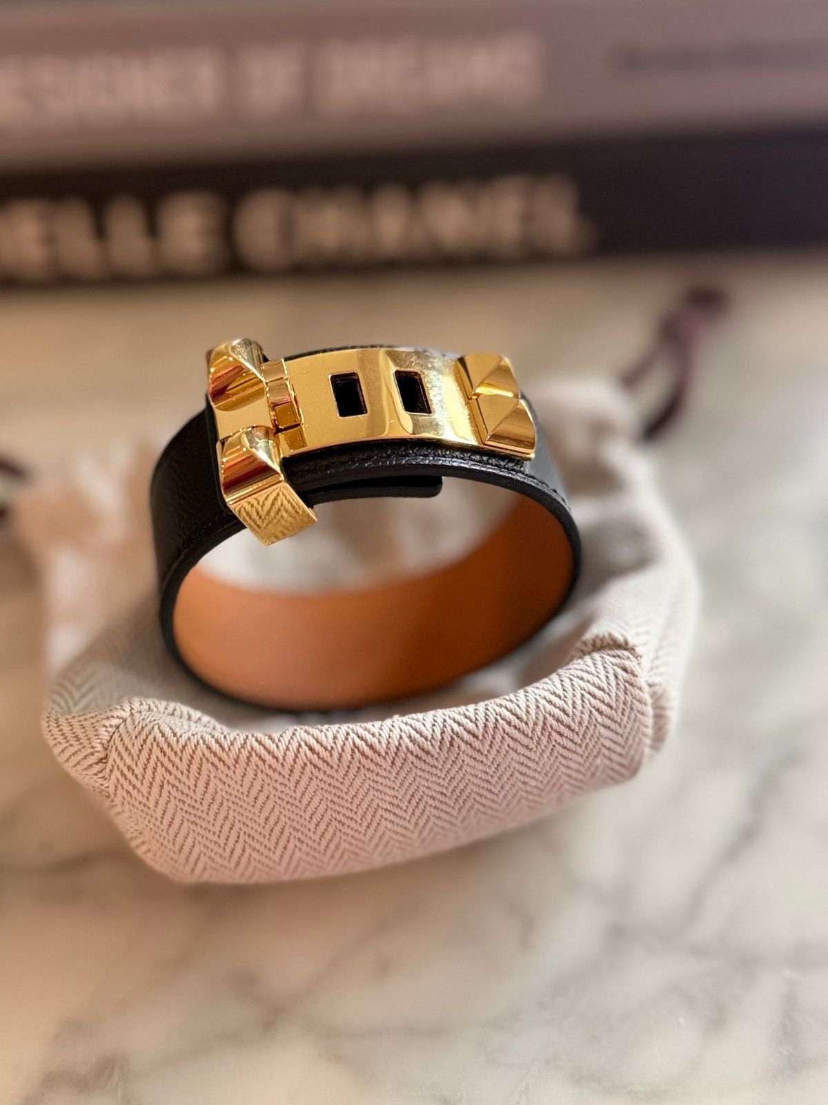 Louise Row featuring Hermes Collier Cuff 24 in black leather on table