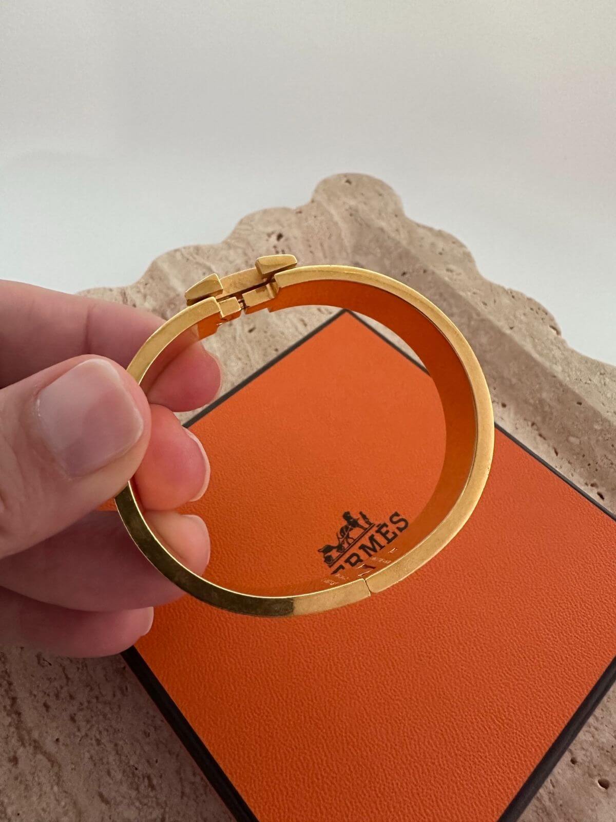 Side view of Hermes Clic H Bracelet with box on marble tray