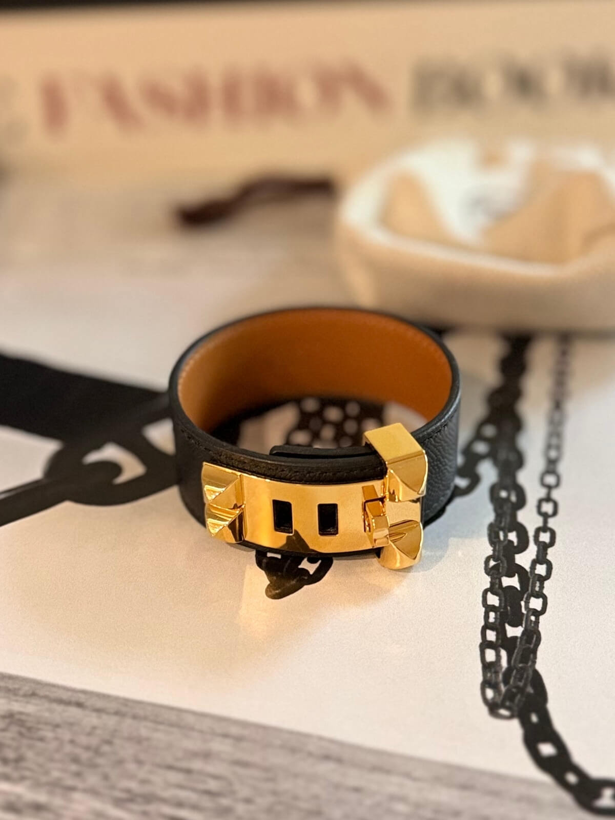 Louise Row featuring Hermes Collier Cuff 24 in black leather on table