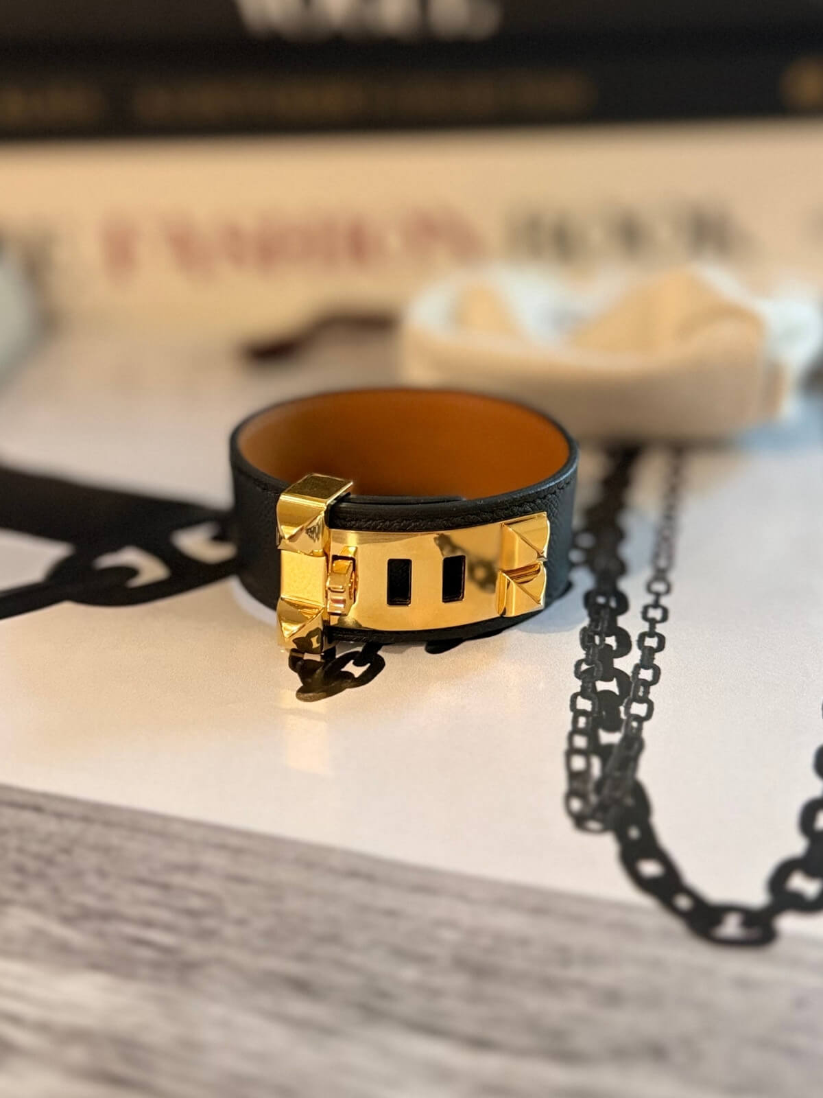 Louise Row featuring Hermes Collier Cuff 24 in black leather on table