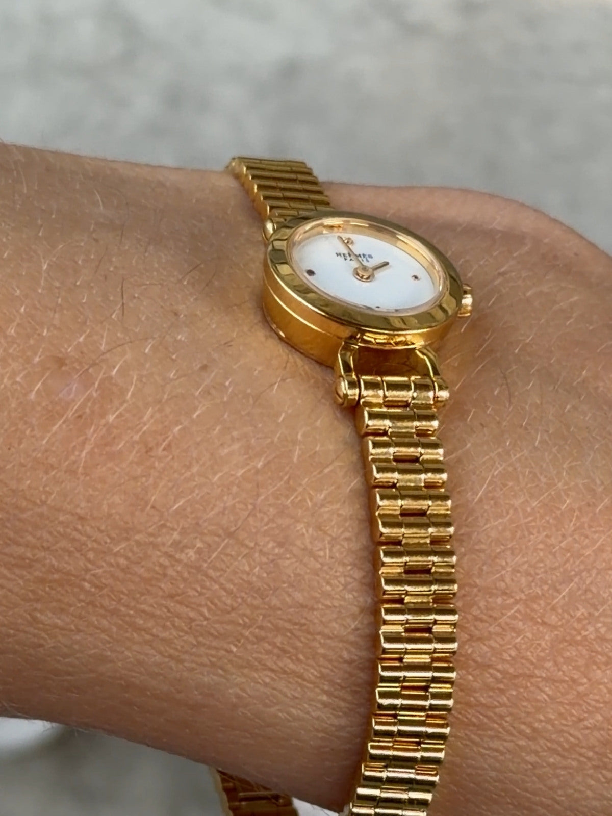 Louise Row featuring Hermes 18K yellow gold Faubourg watch on hand showing signature on back side