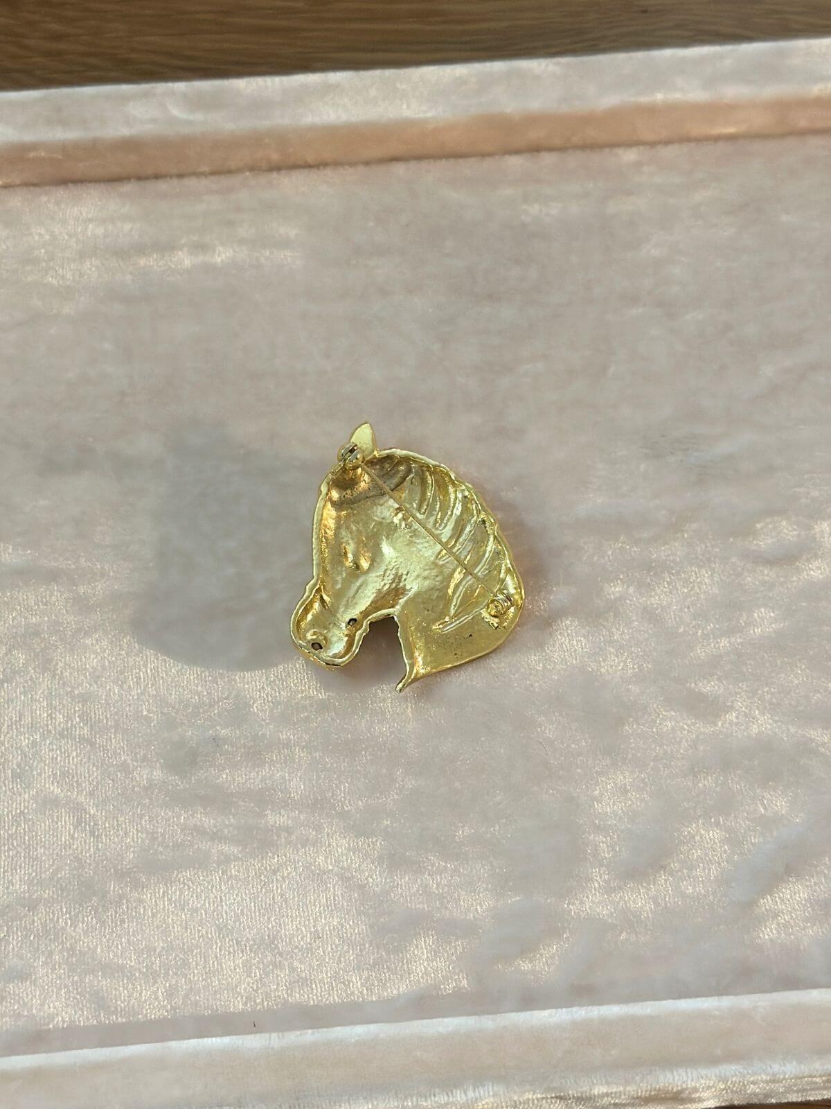 Louise Row Studio  Vintage gold Horse Brooch on pink display tray, showing back side.