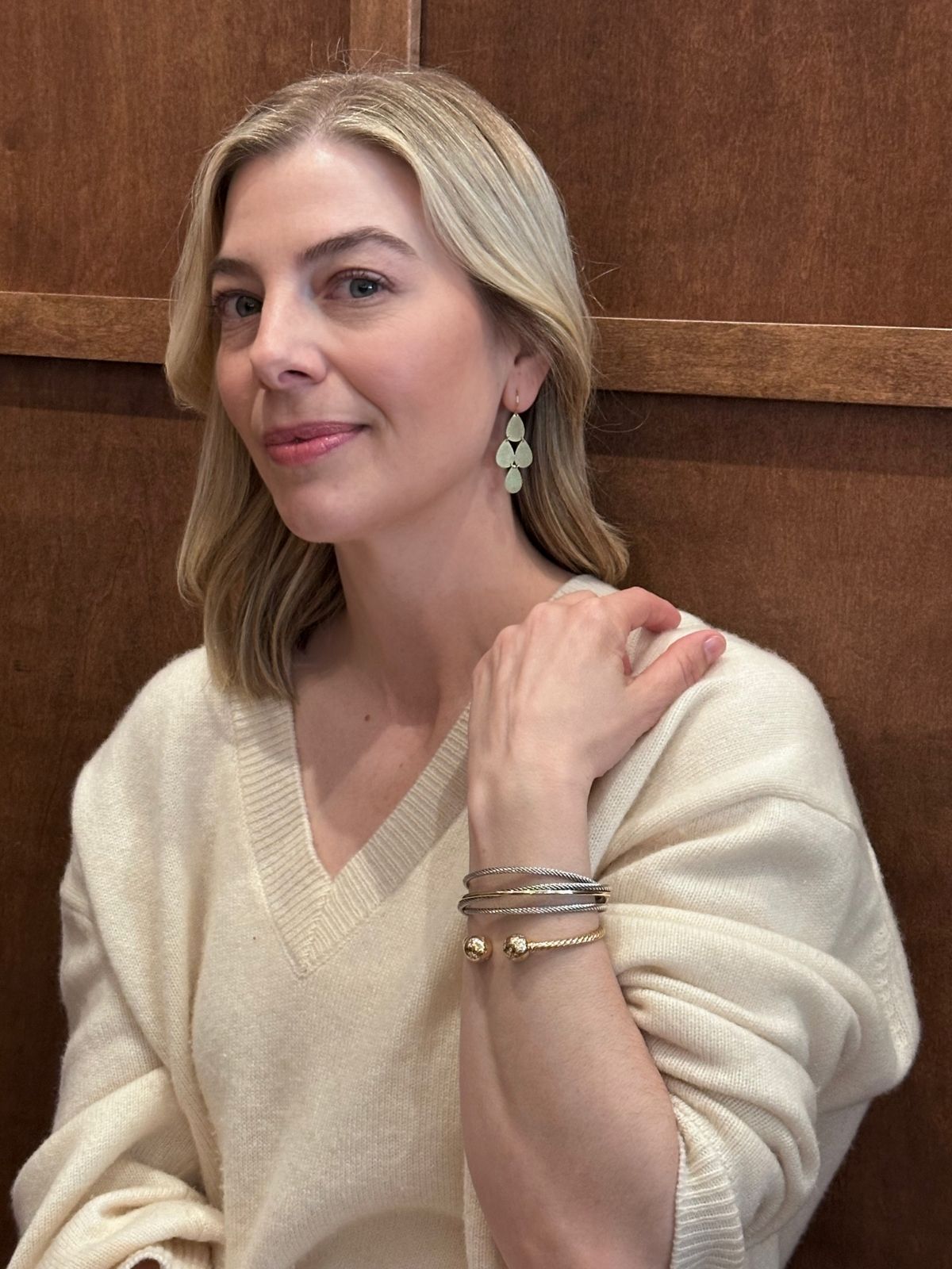 Louise Row Studio featuring Irene Neuwirth gold drop earrings on model in white sweater.