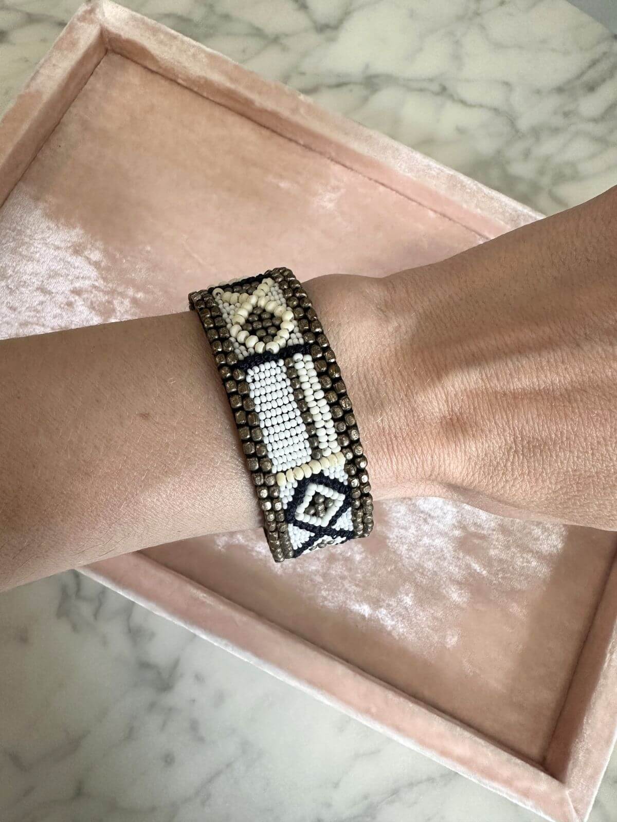 Louise Row Studio featuring Isabel Marant beaded cuff on arm on pink tray