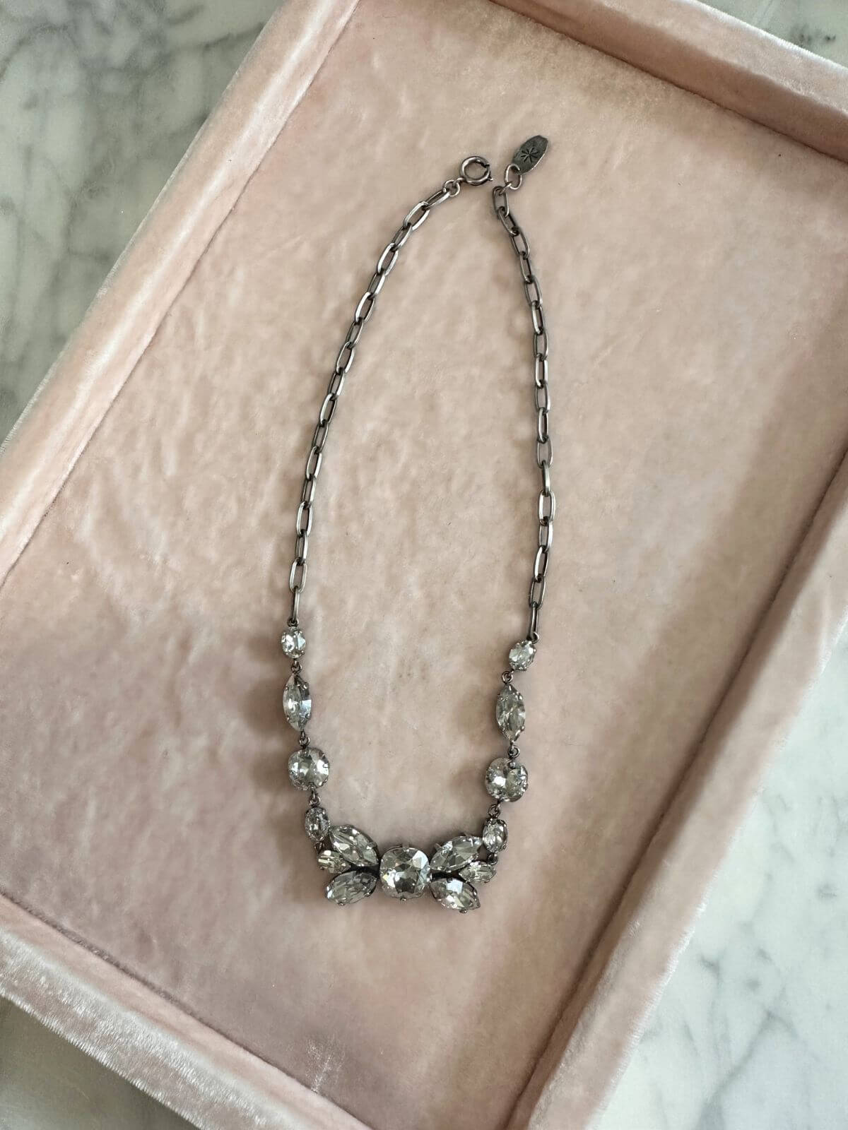 Louise Row Studio featuring Isabel Marant Necklace  with crystals on pink tray.