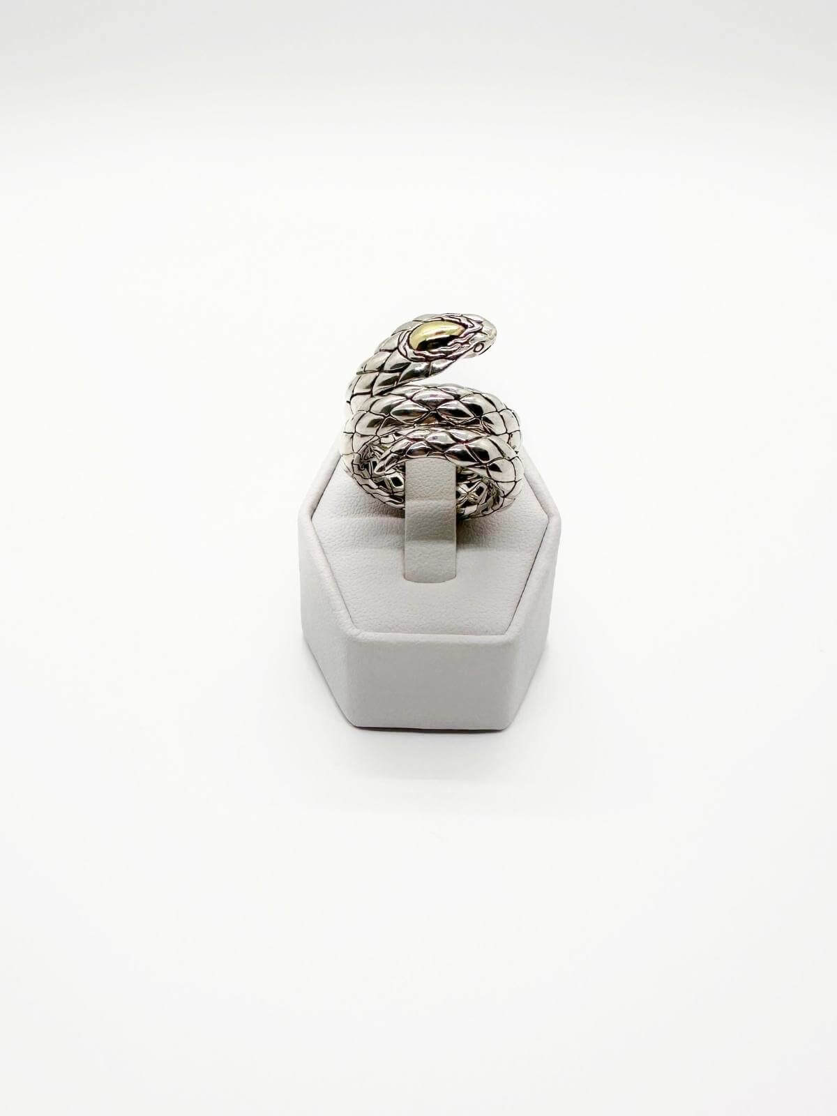 JOhn Hardy Silver snake-shaped ring on a white stand against a white background