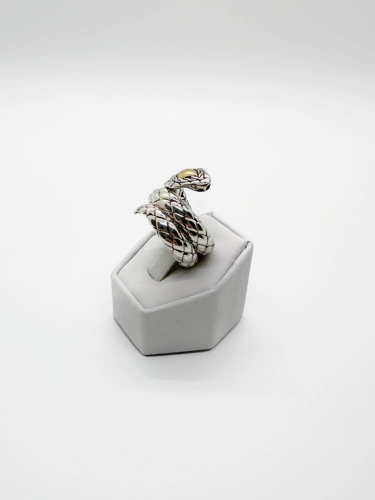 JOhn Hardy Silver snake-shaped ring on a white stand against a white background