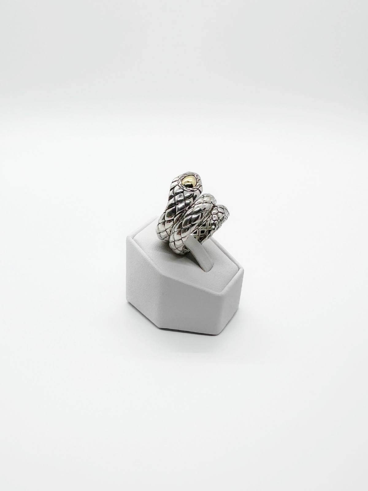 JOhn Hardy Silver snake-shaped ring on a white stand against a white background