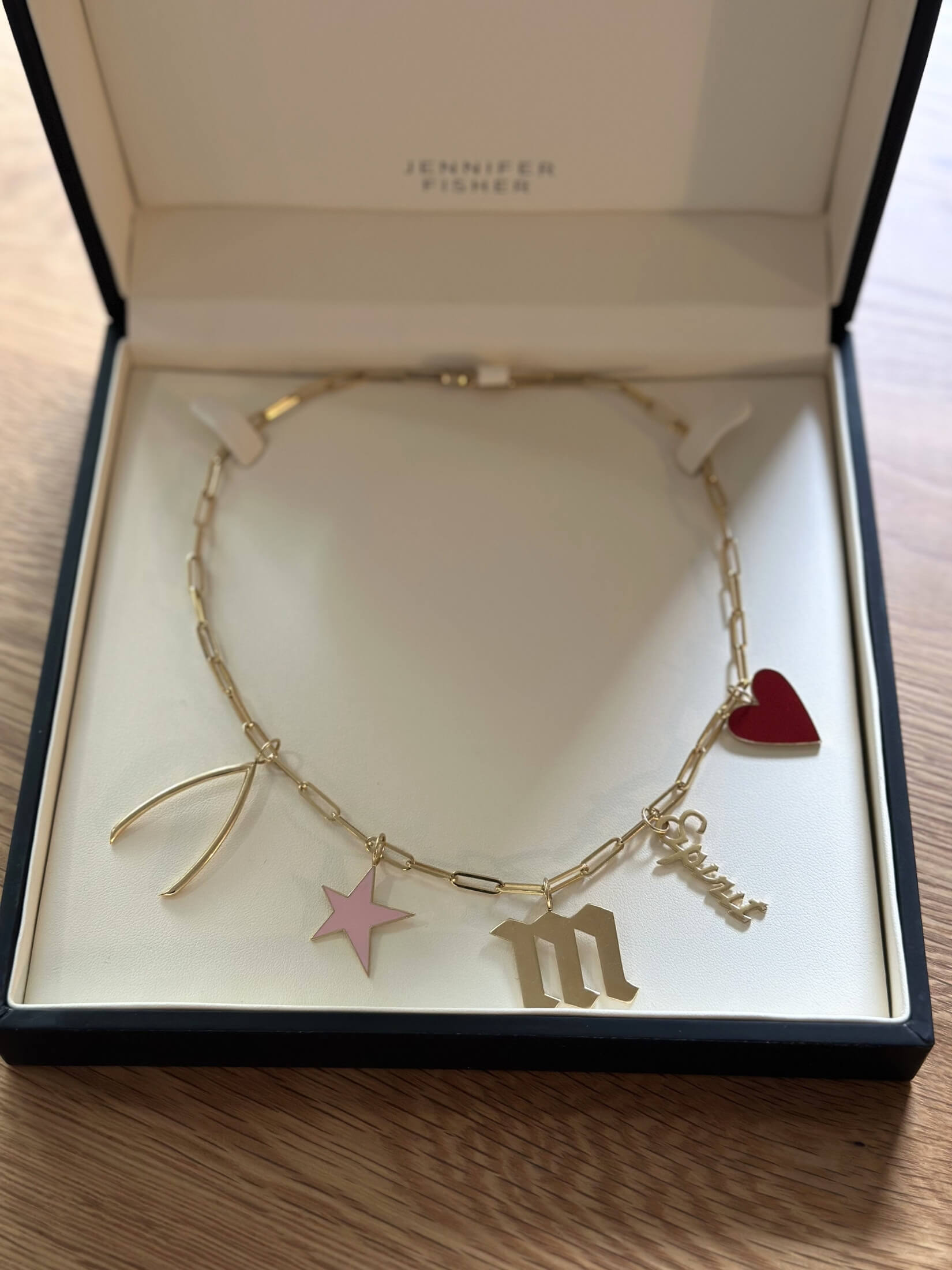 Louise Row Studio featuring Jennifer Fisher enamel heart charm shown with others on necklace in box