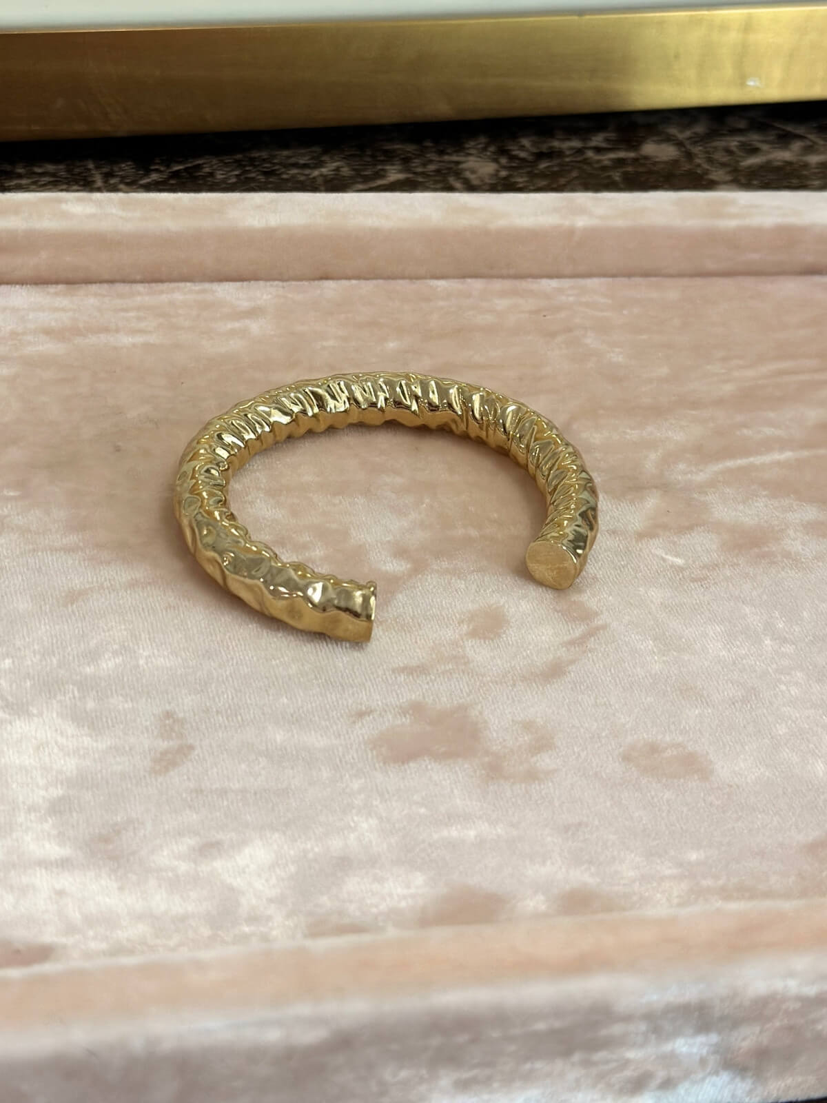 Louise Row featuring Jennifer Fisher Maeve gold hammered cuff on pink pad. 
