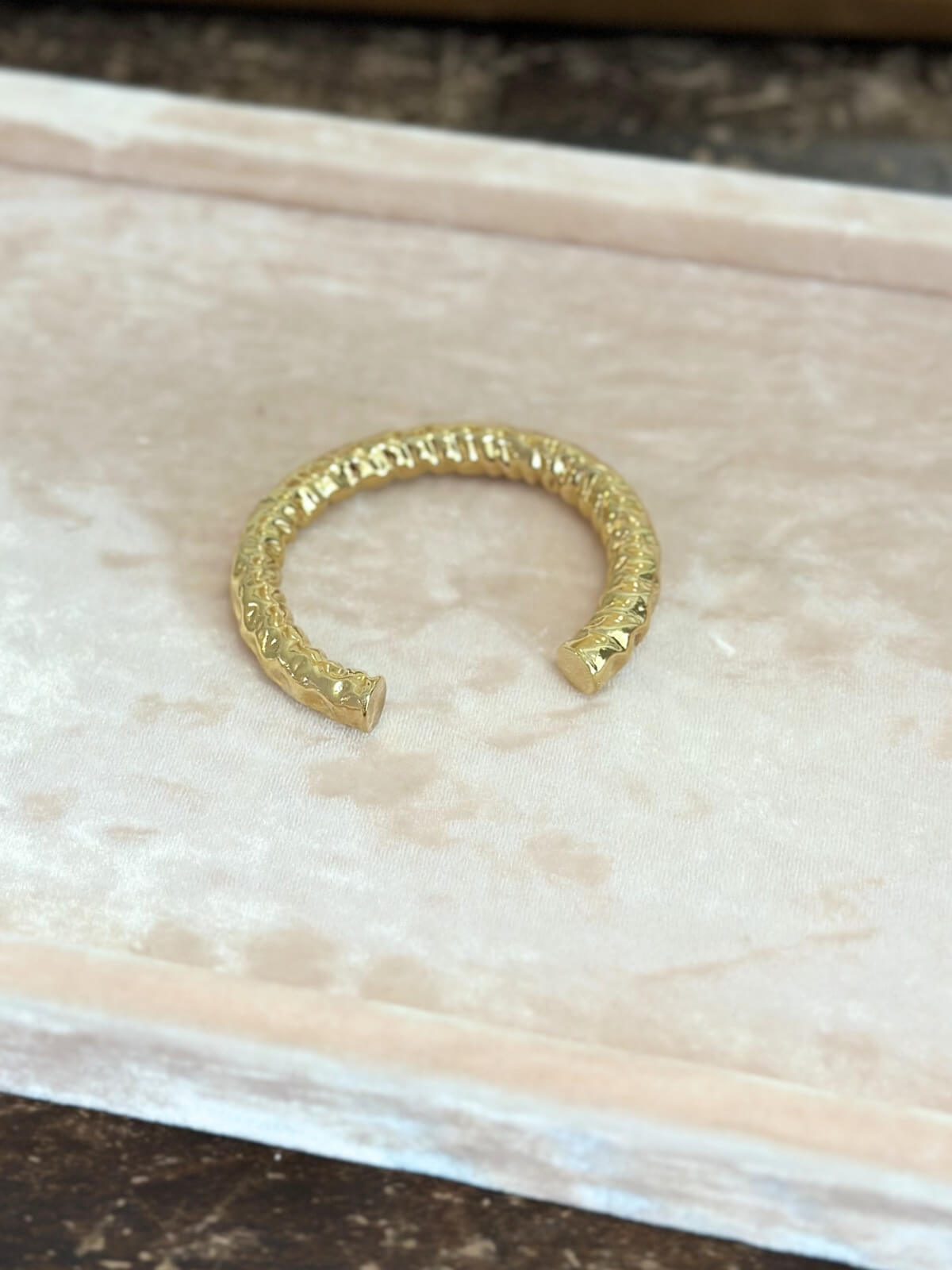 Louise Row featuring Jennifer Fisher Maeve gold hammered cuff on pink pad. 