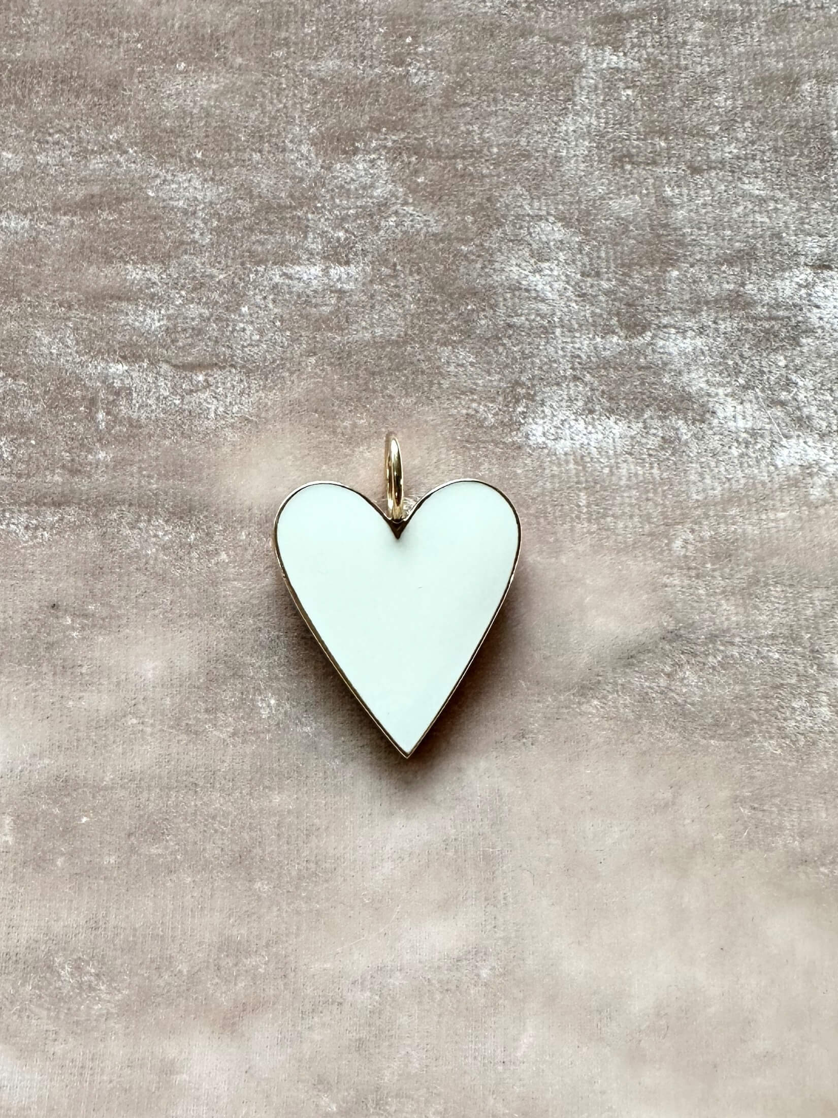 Louise Row Studio featuring Jennifer Fisher enamel heart charm on pink background