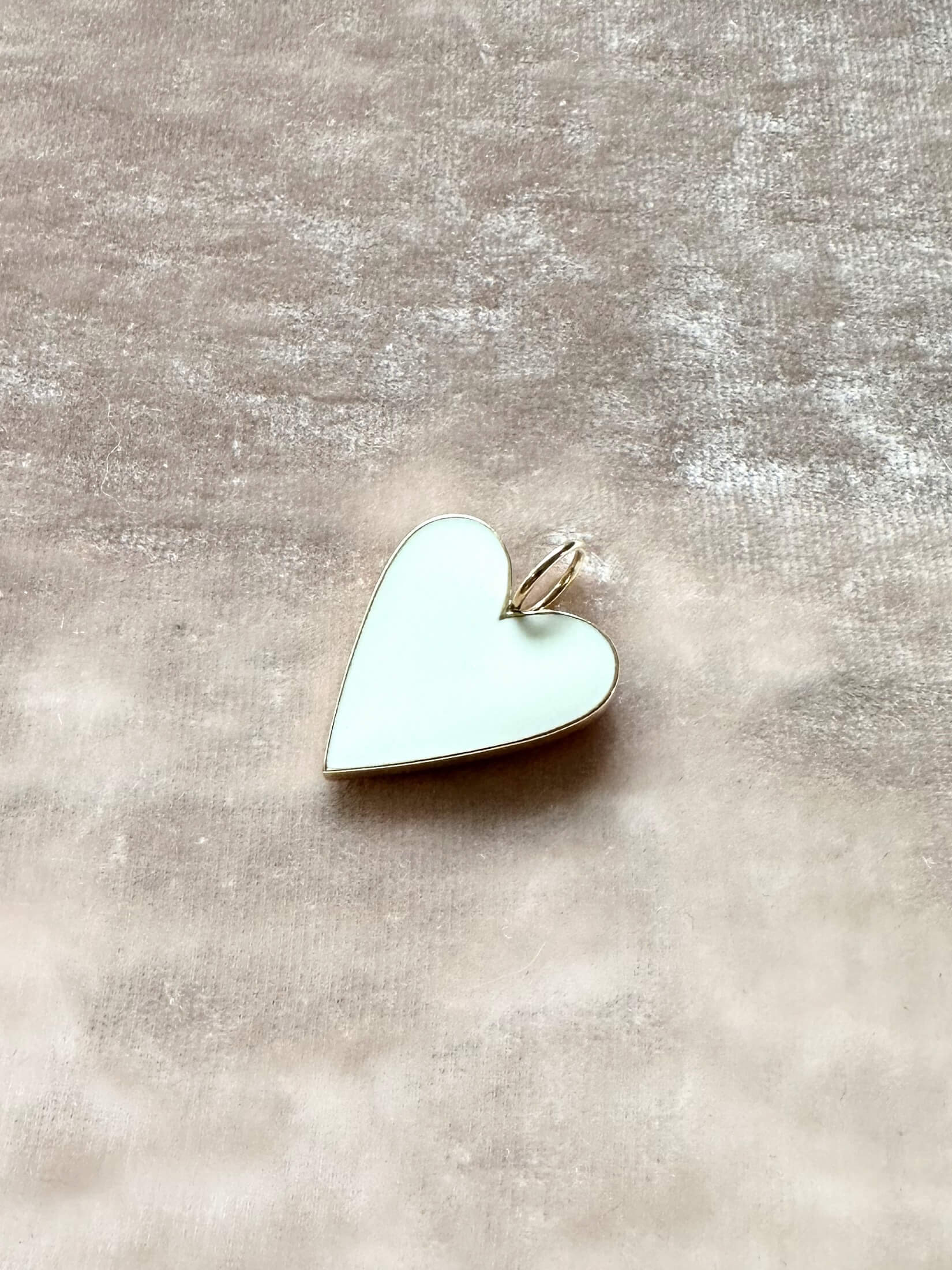 Louise Row Studio featuring Jennifer Fisher enamel heart charm on pink background