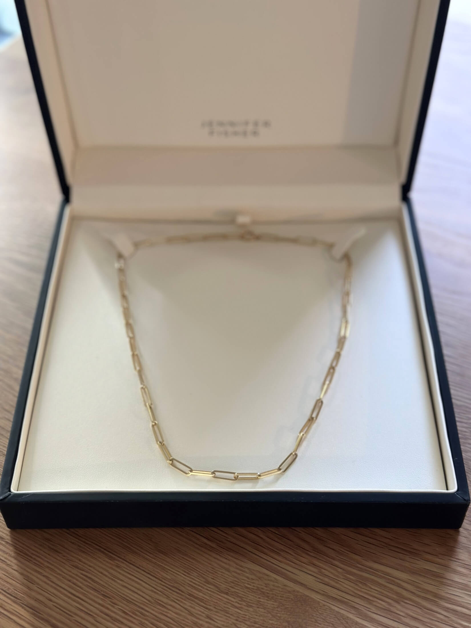 Louise Row featuring Jennifer Fisher gold paperclip necklace in box on table