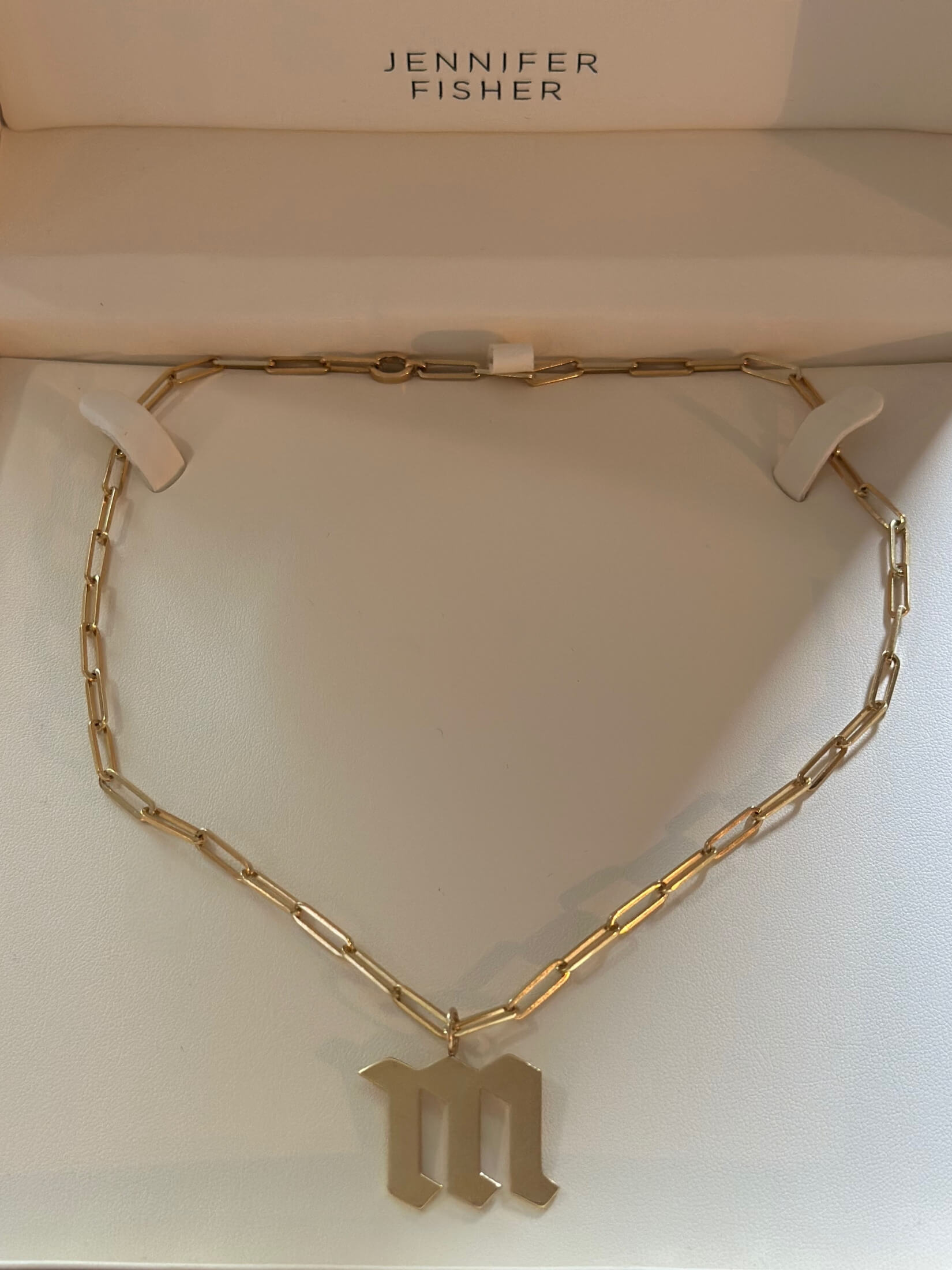Louise Row featuring Jennifer Fisher M charm on necklace in box