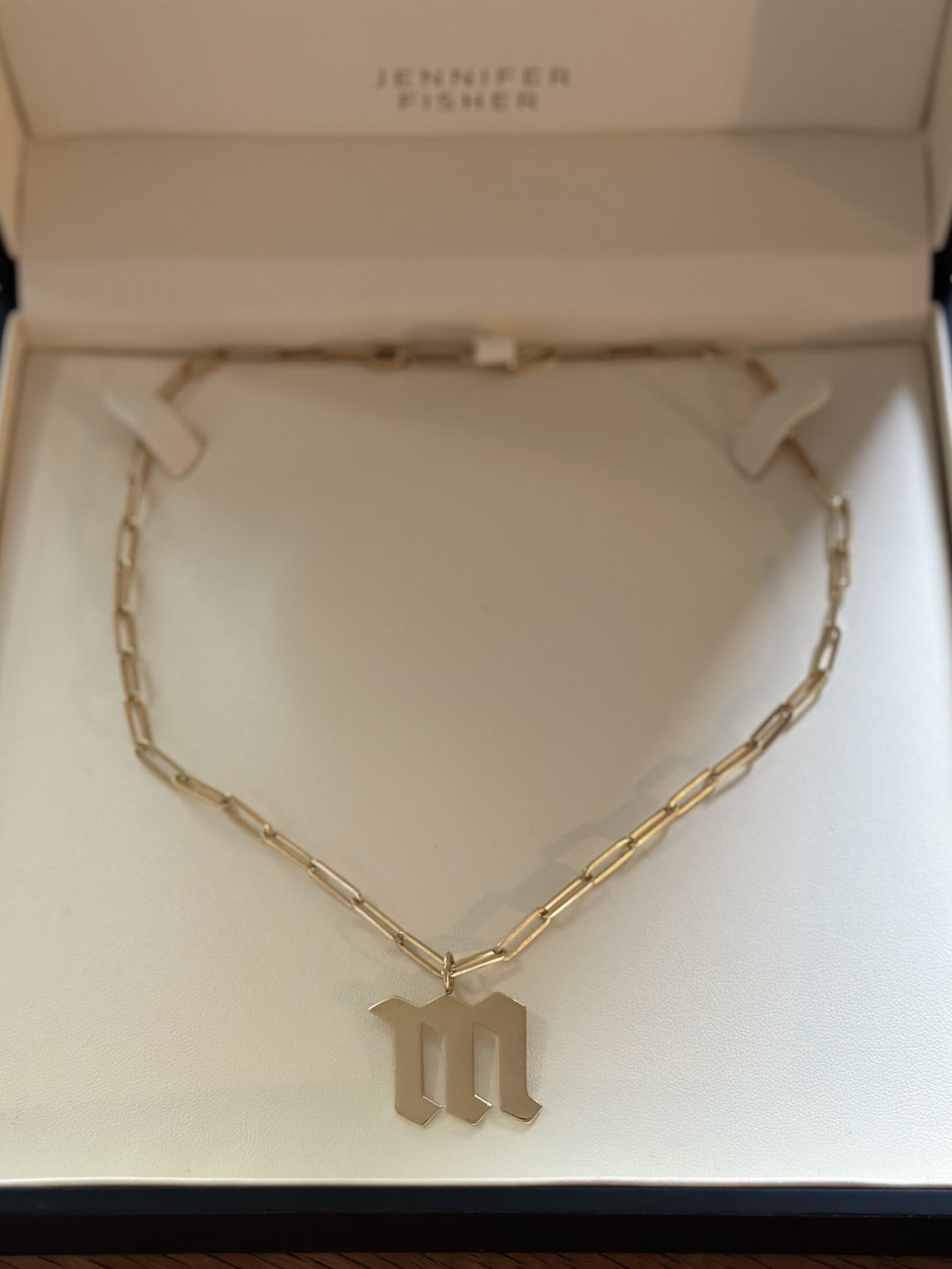 Louise Row featuring Jennifer Fisher M charm on necklace in box
