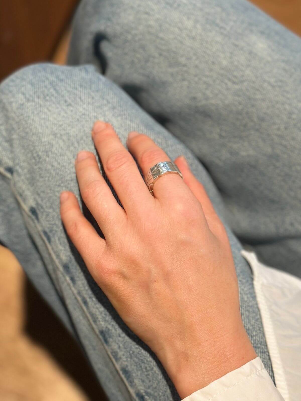 MOdel's hand wearing John Hardy Silver ring with chevron design on .