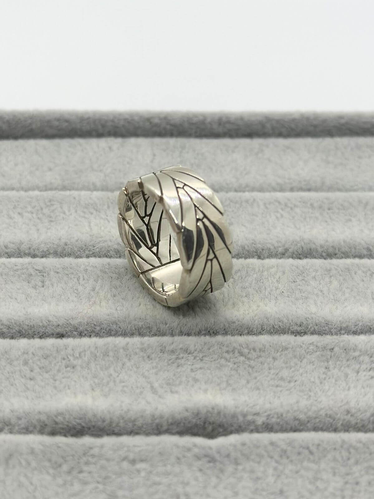 John Hardy Silver ring with chevron design on grey fixture