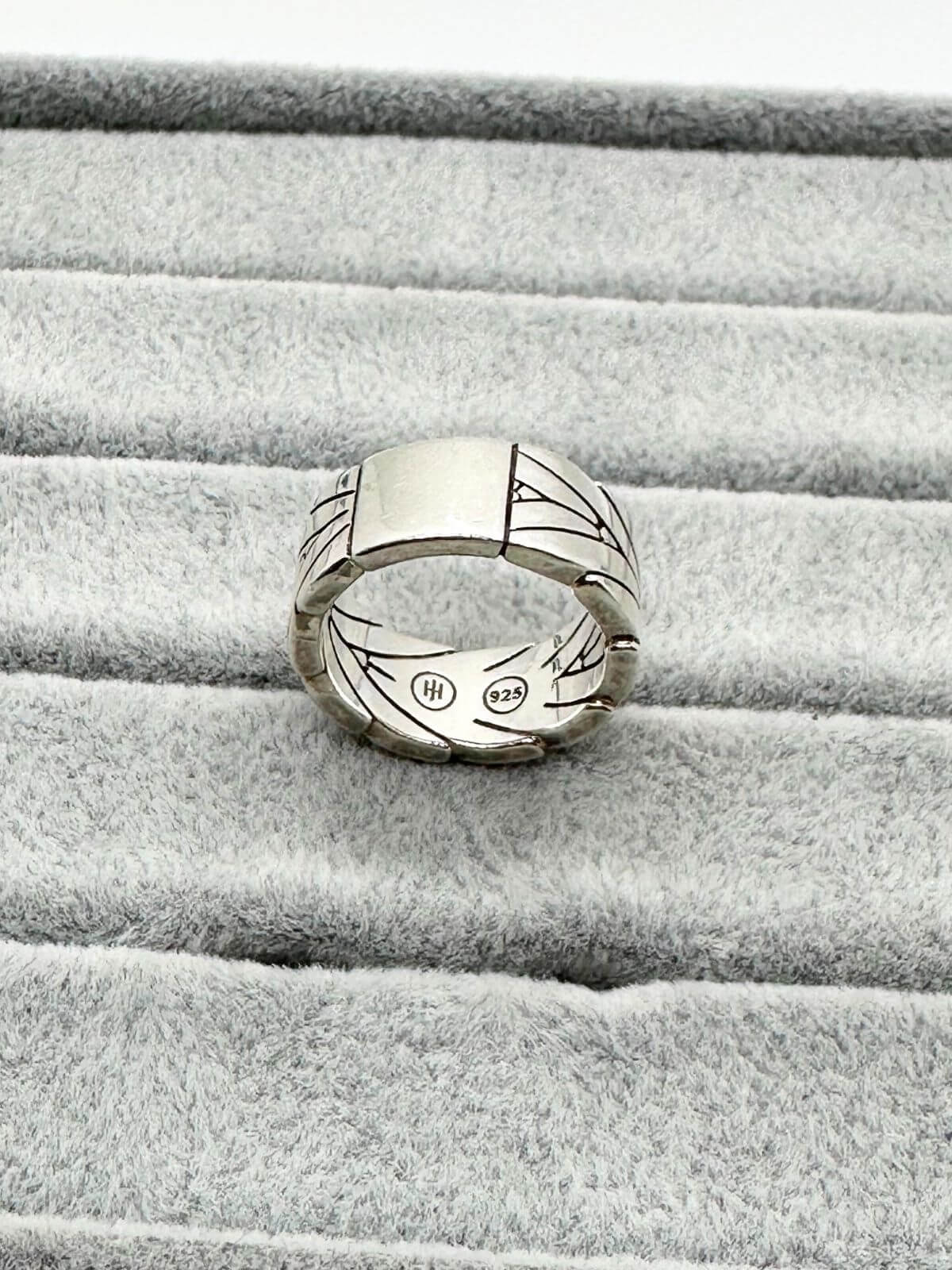John Hardy Silver ring with chevron design on grey fixture