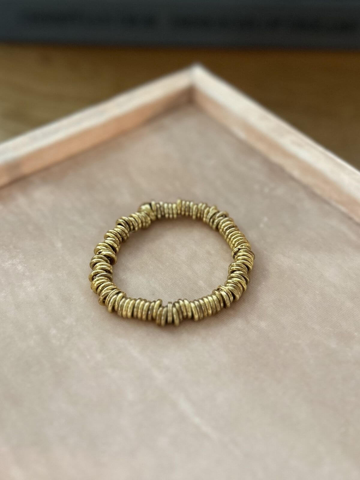 Gold sweetie bracelet on pink background