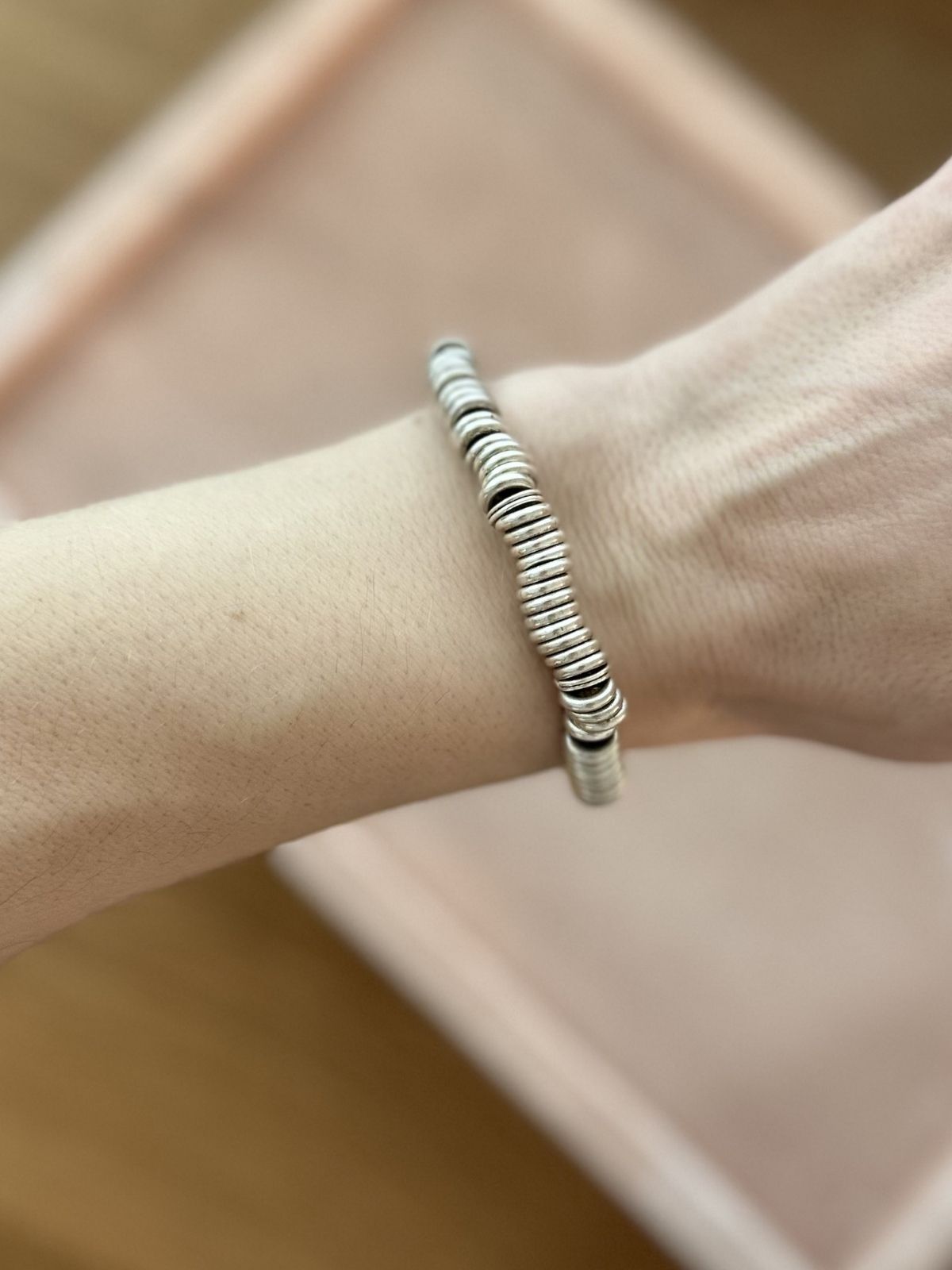 Silver Link of London Sweetie bracelet on pink background on arm