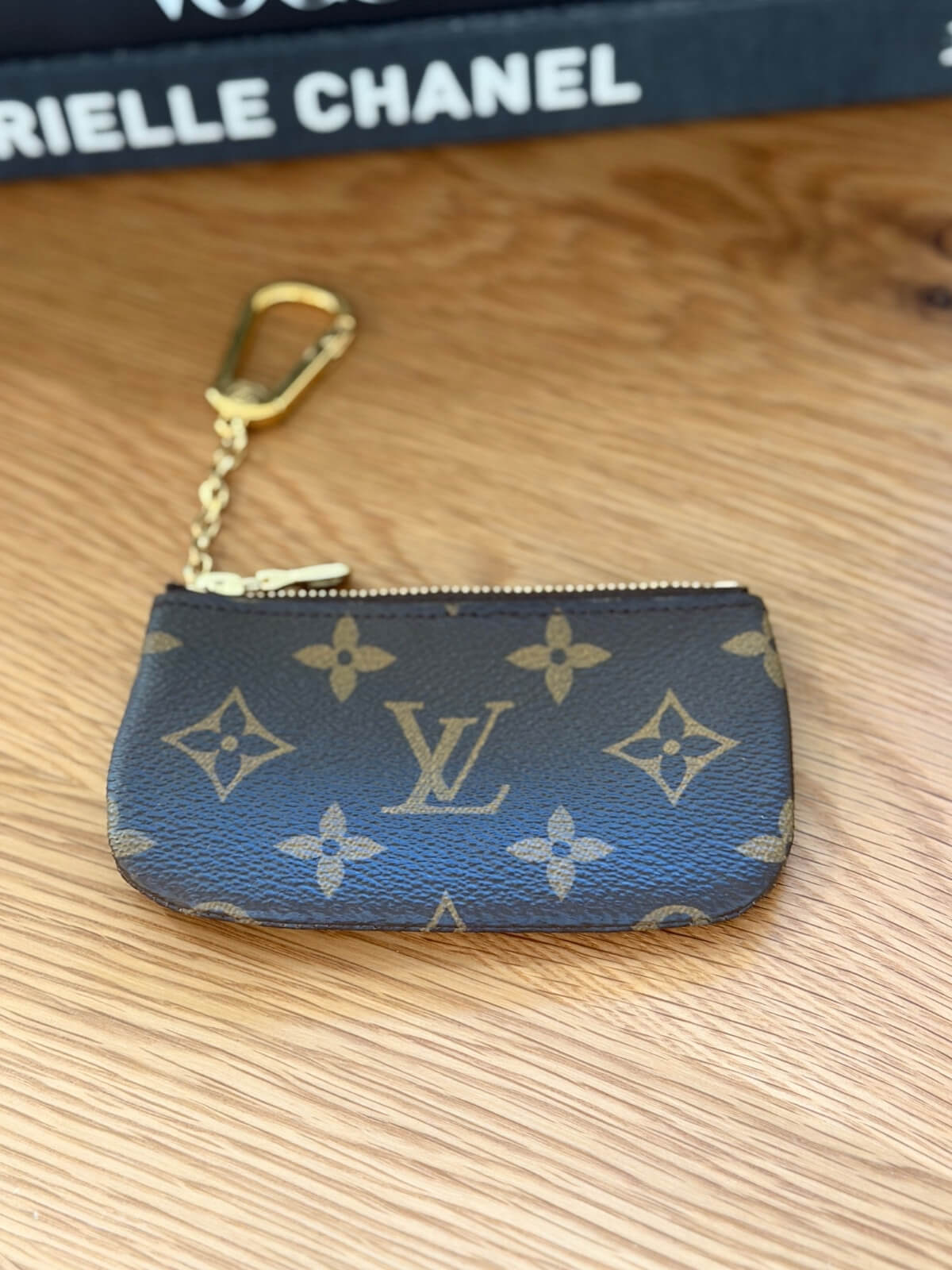 Louise Row featuring LV key pouch on table with books.