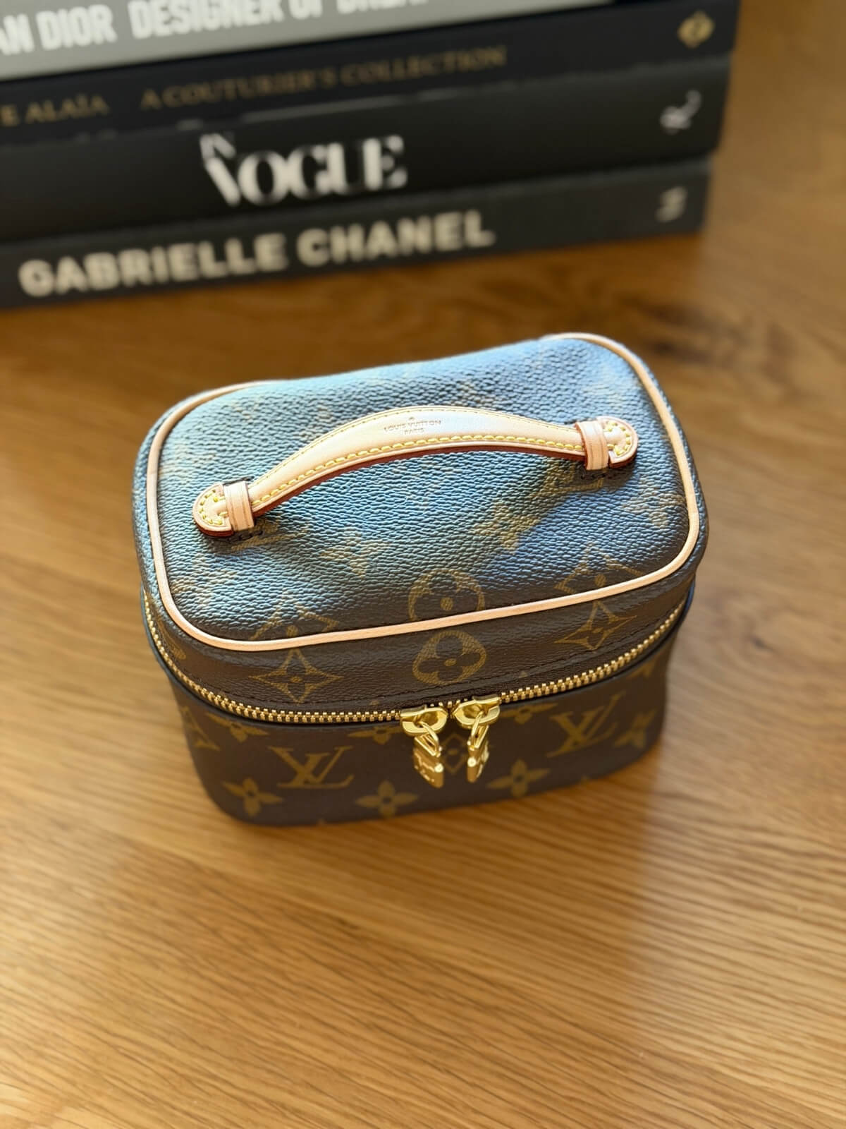 Louise Row featuring Louis Vuitton Nice Nano Vanity case on table with books