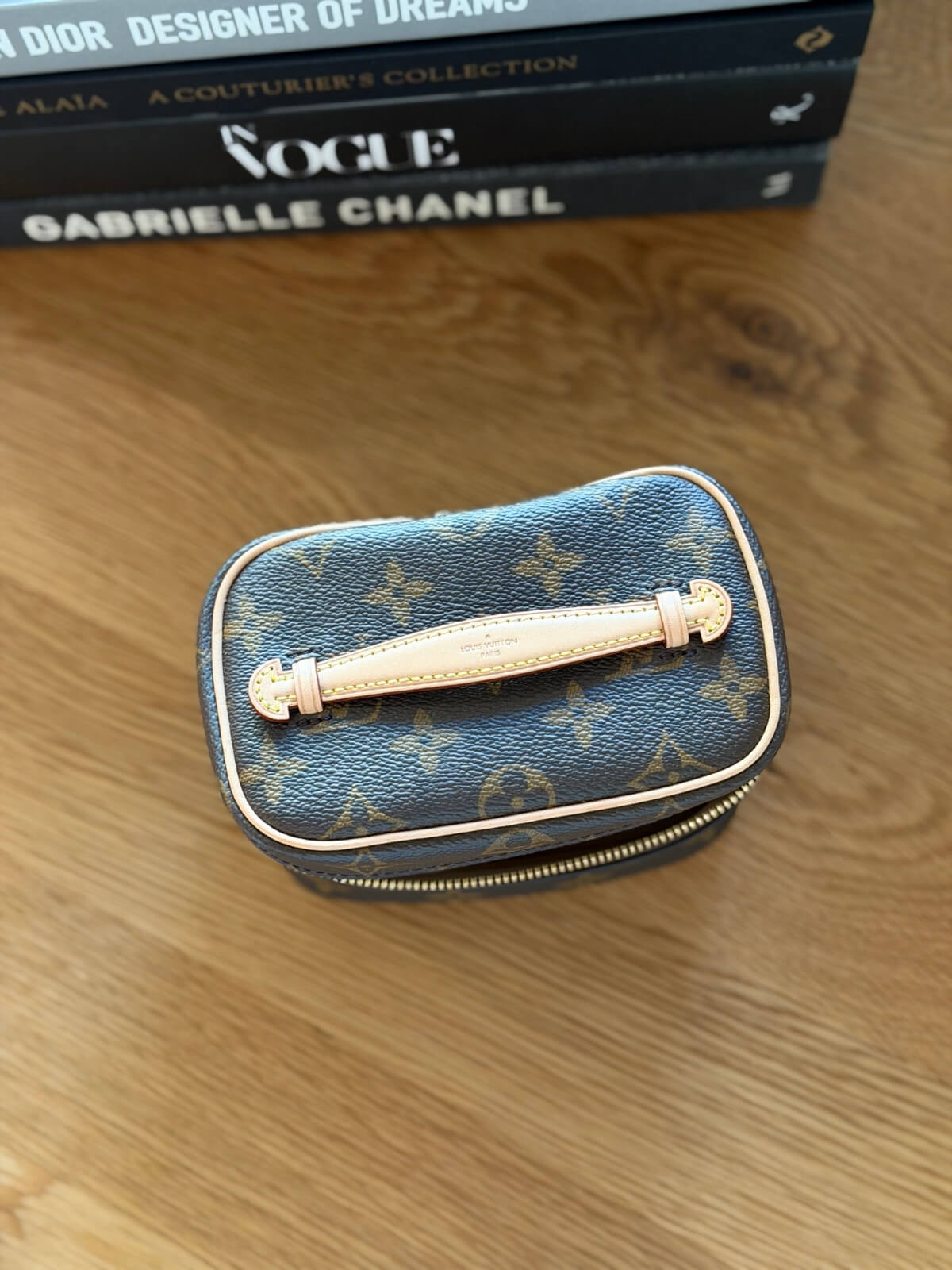 Louise Row featuring Louis Vuitton Nice Nano Vanity case on table with books