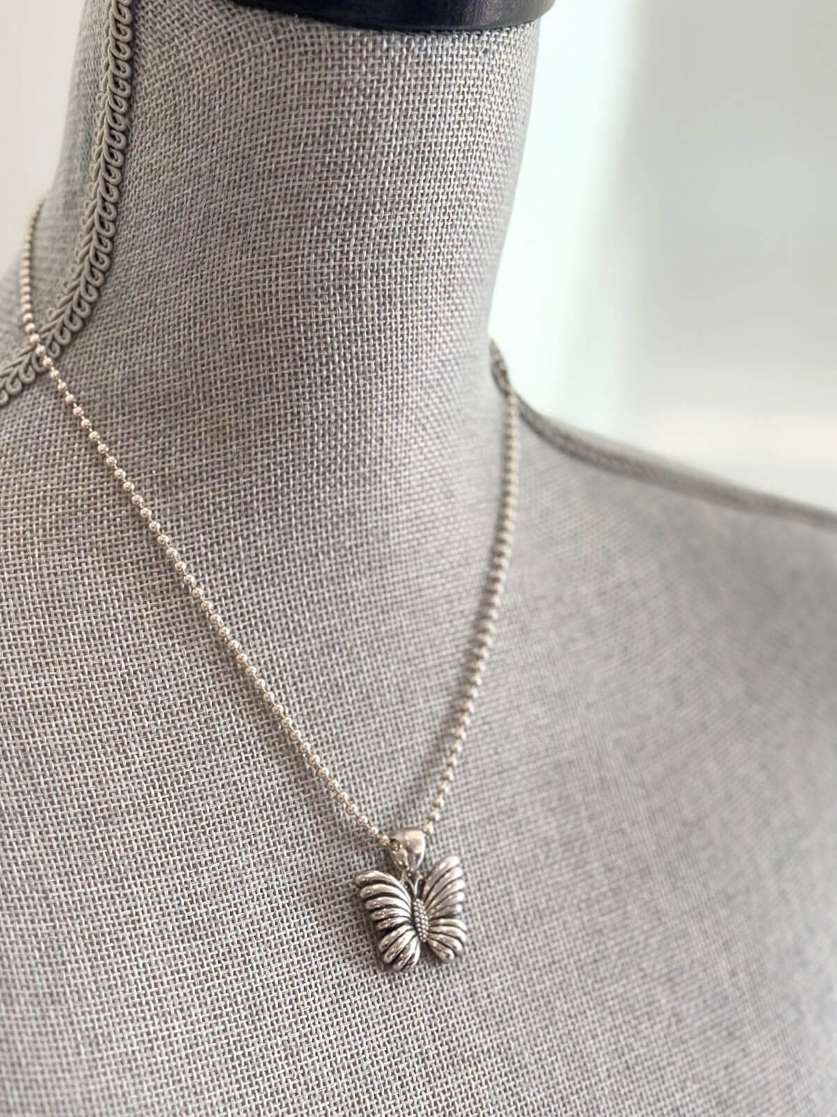 Louise Row featuring Lagos silver butterfly necklace on grey mannequin