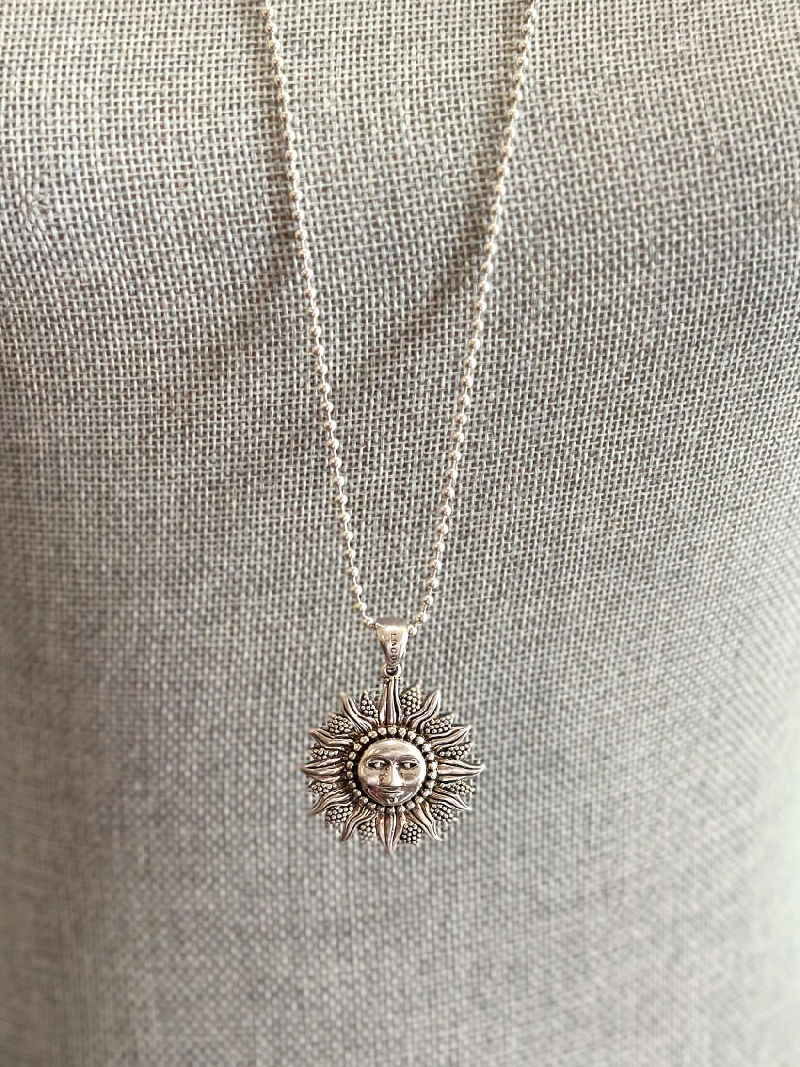 Louise Row featuring silver Lago Sun necklace on grey mannequin
