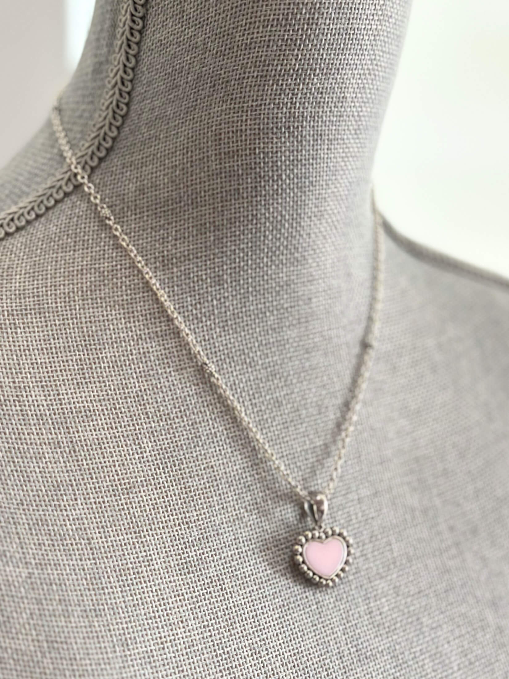 Louise Row featuring Lago pink ceramic heart necklace on grey mannequin