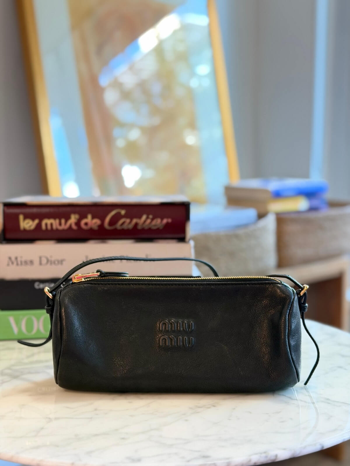 Louise Row featuring Miu Miu Nappa Black shoulder bag on table with books