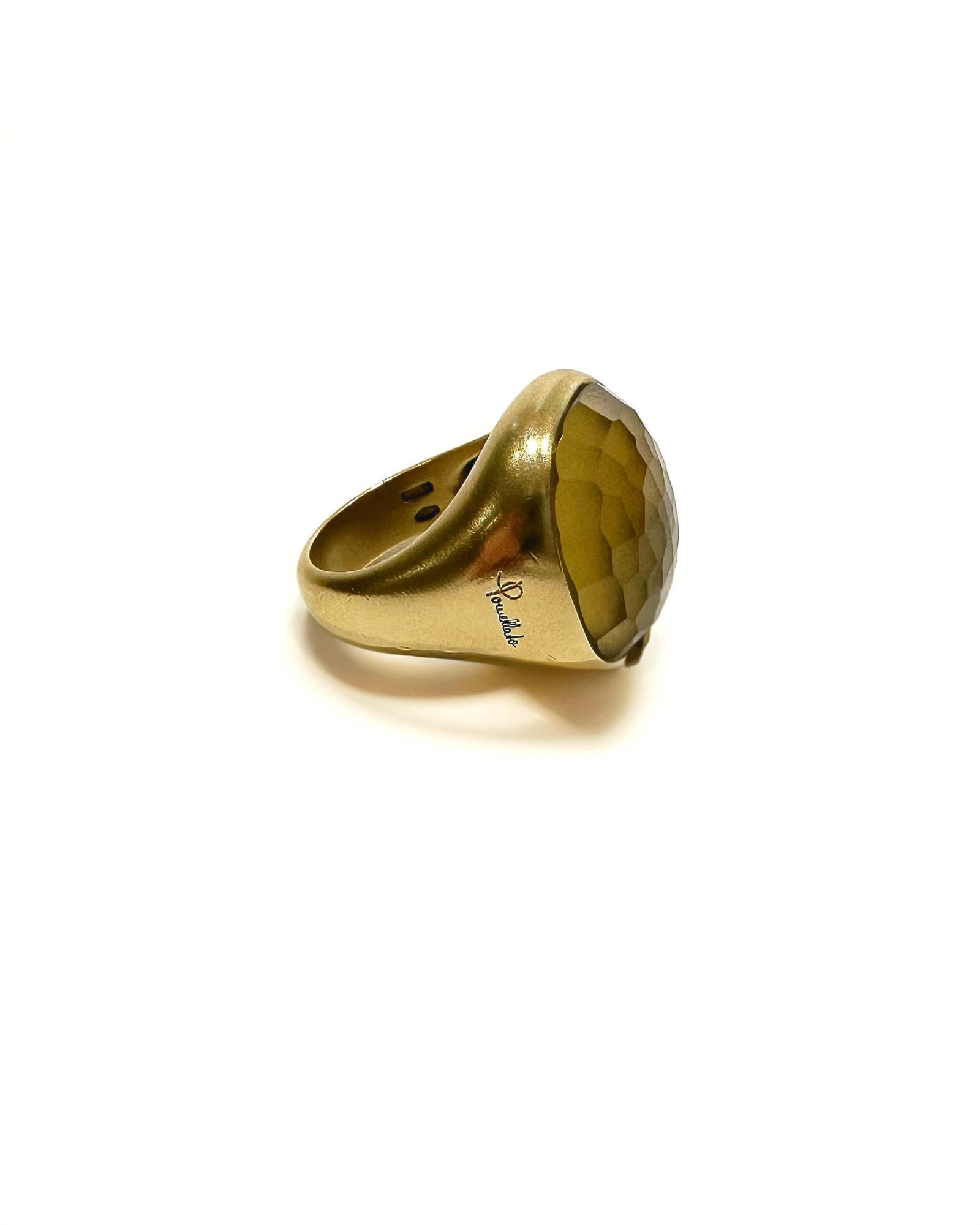 Gold ring with a large green/yellow gemstone on a white background