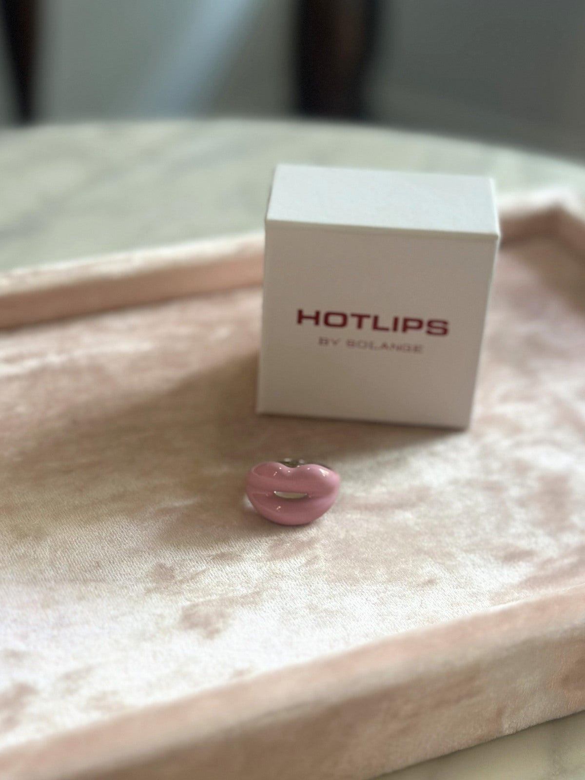 Louise Row featuring Solange Hotlips ring, on box on pink pad