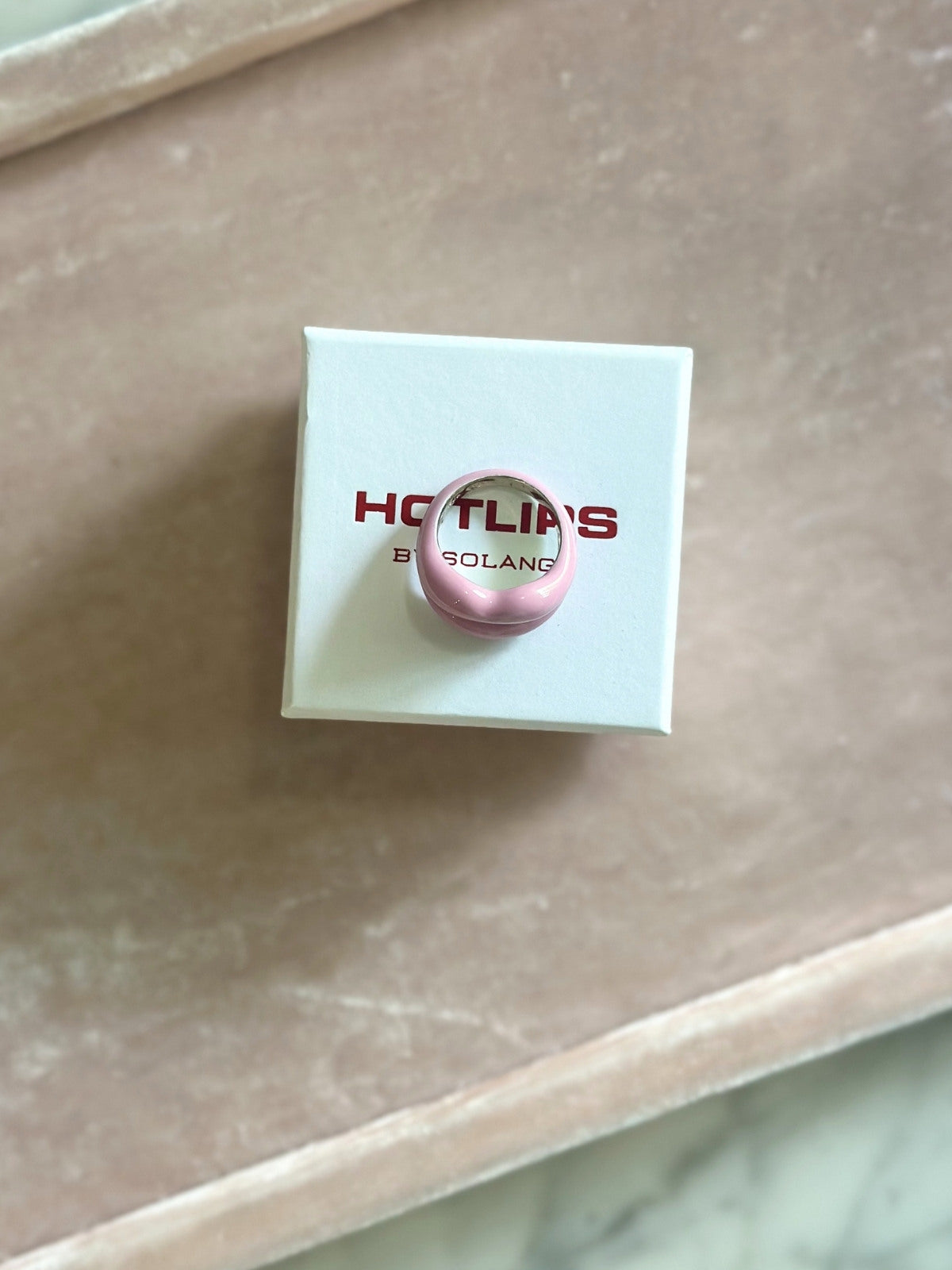 Louise Row featuring Solange Hotlips ring, on box on pink pad