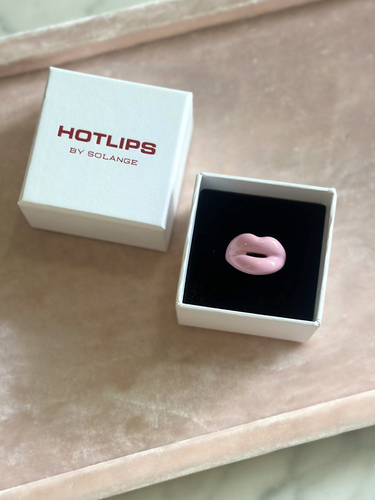 Louise Row featuring Solange Hotlips ring, on box on pink pad