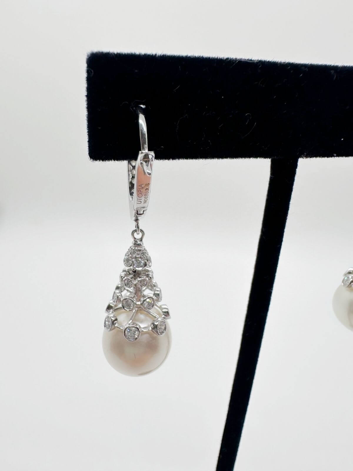 South Sea pearl and diamond drop earring with white background and on black fixture. 