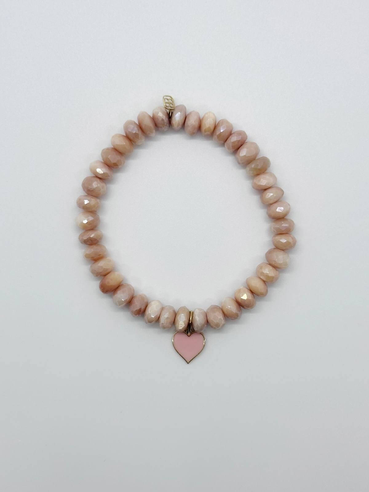 Beaded bracelet with a heart charm on a white background