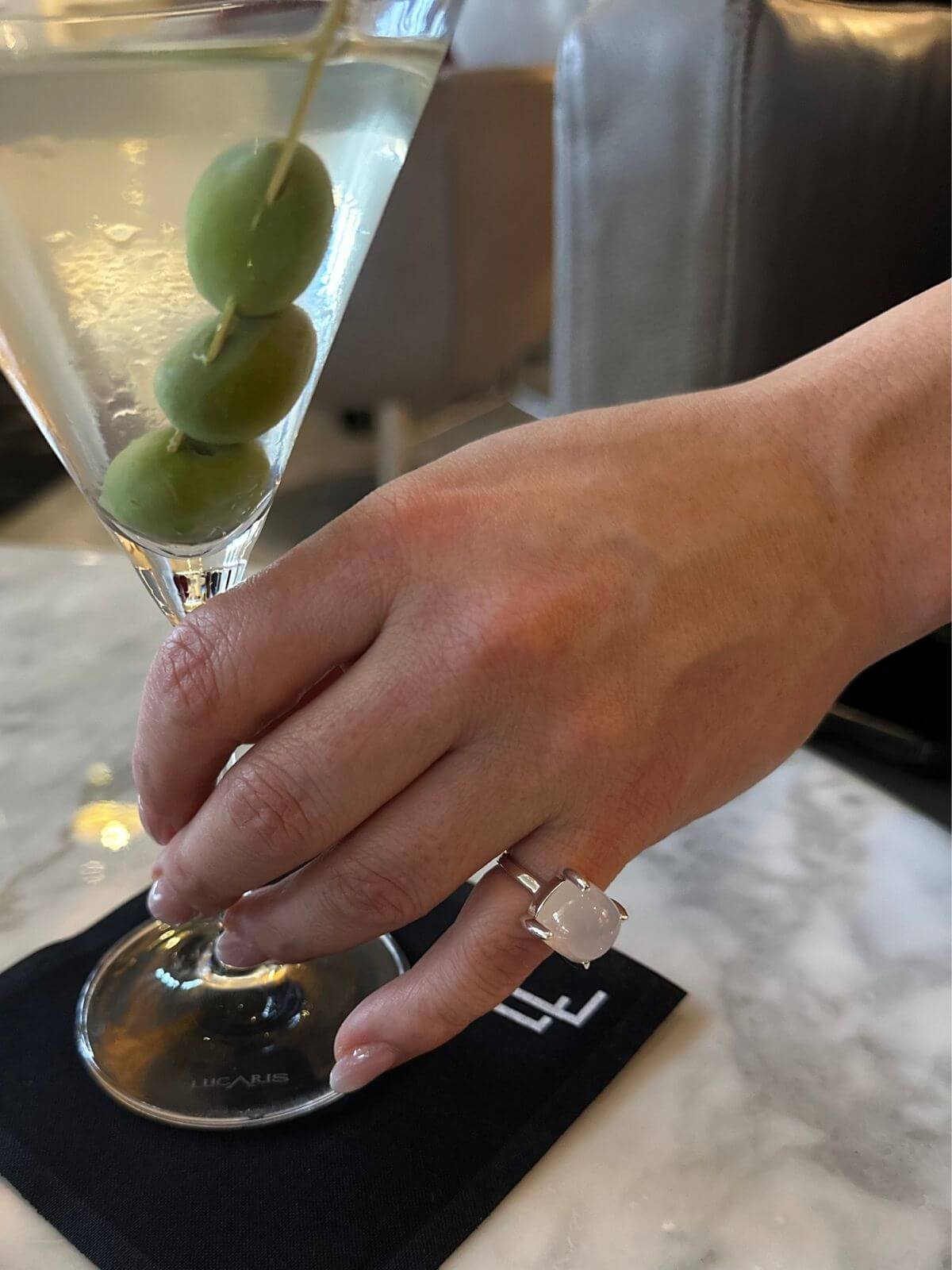 Model hand with Tiffany ring holding martini