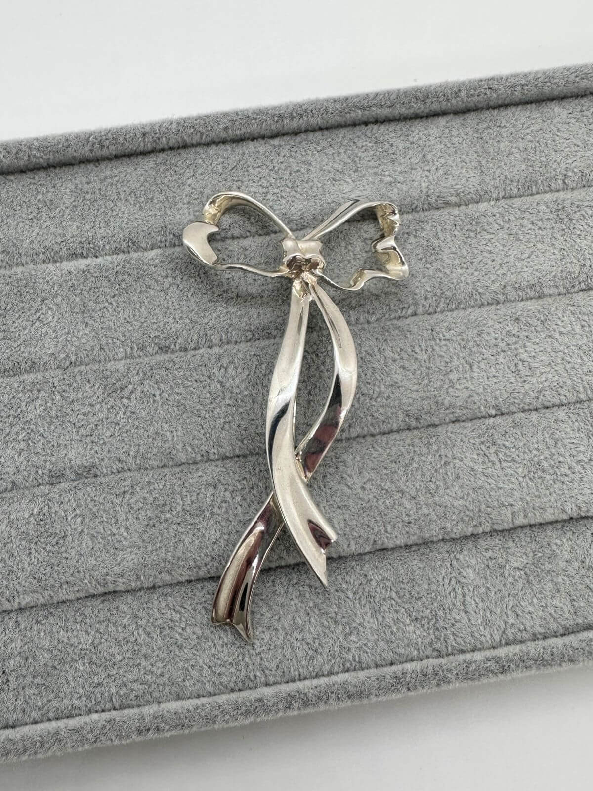 Tiffany bow brooch on grey background