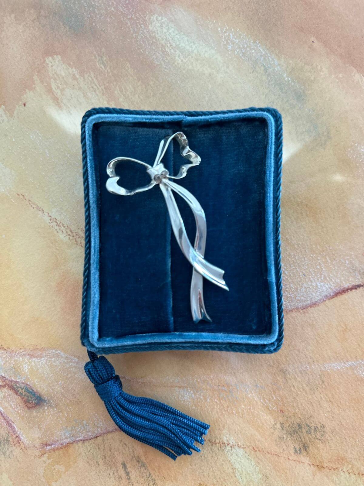 TIffany bow brooch on blue fixture