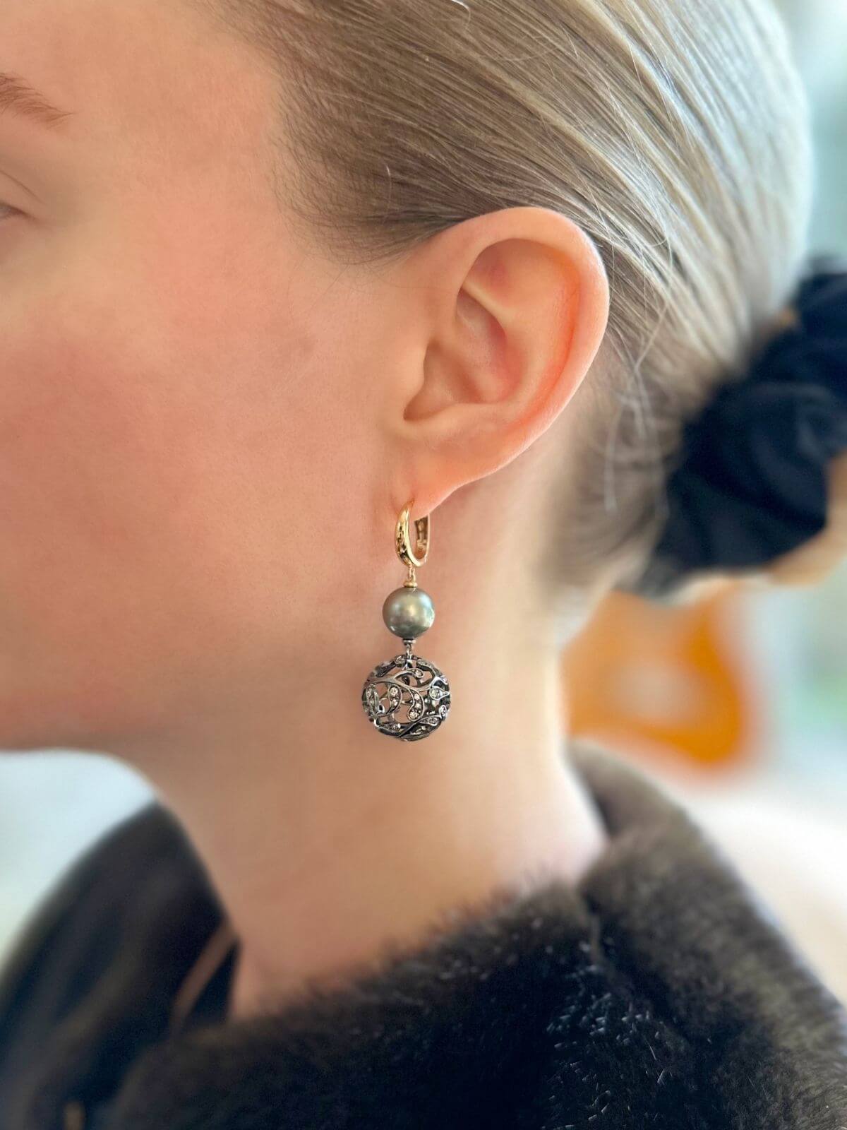 Model in Tahitian pearl drop earrings , close-up.