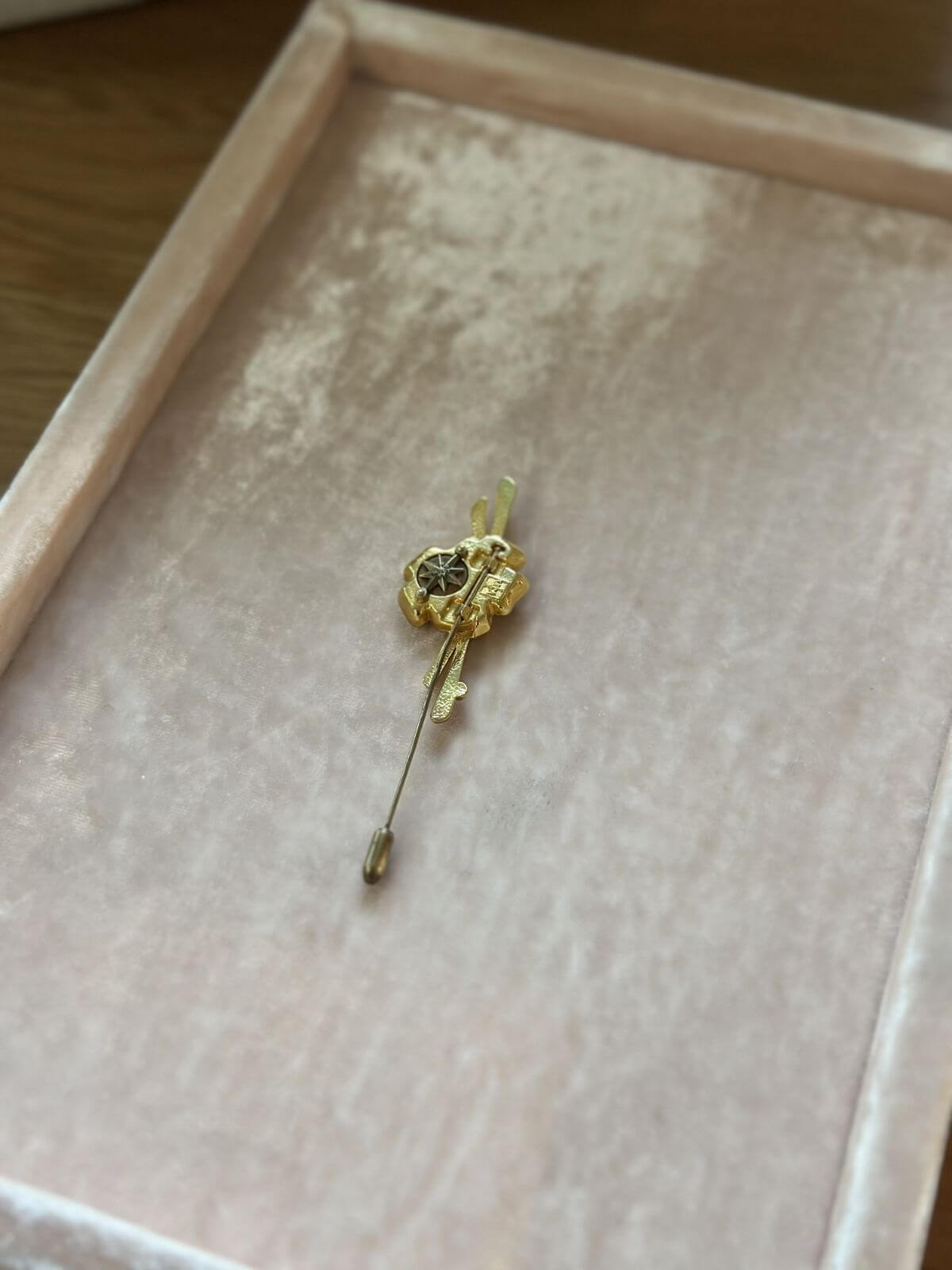 Louise Row Studio vintage Van Cleef & Arpels gold pin brooch on pink display tray.