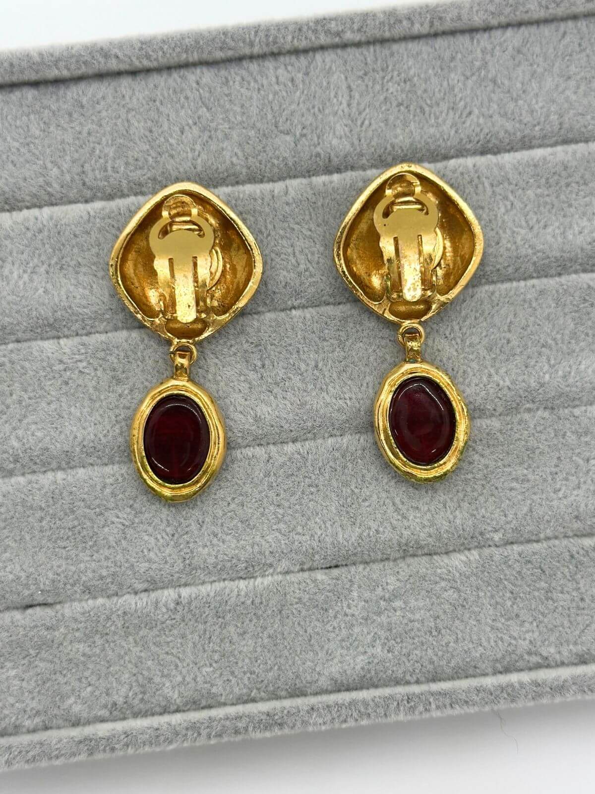 Chanel gold and red Gripoix earring on grey background. Showing back of earring.