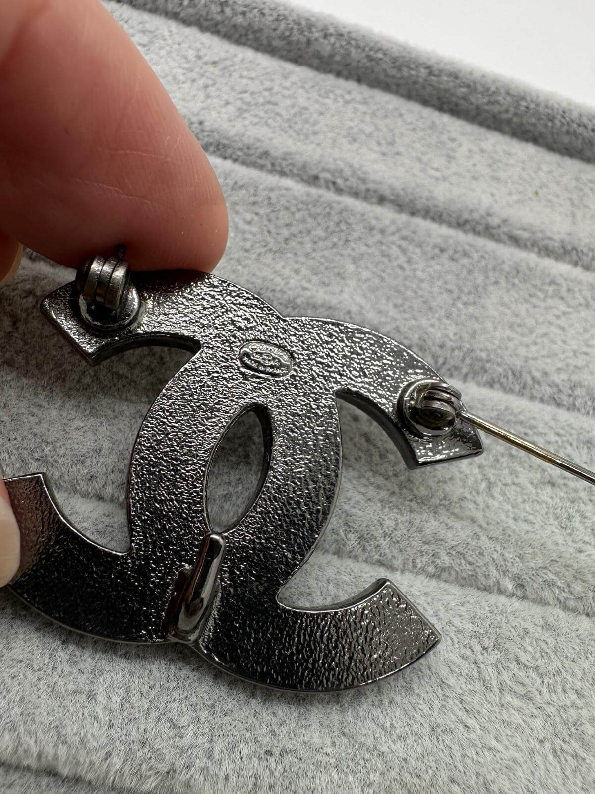 Pre-loved Chanel Multi color brooch on grey background with signature on back 