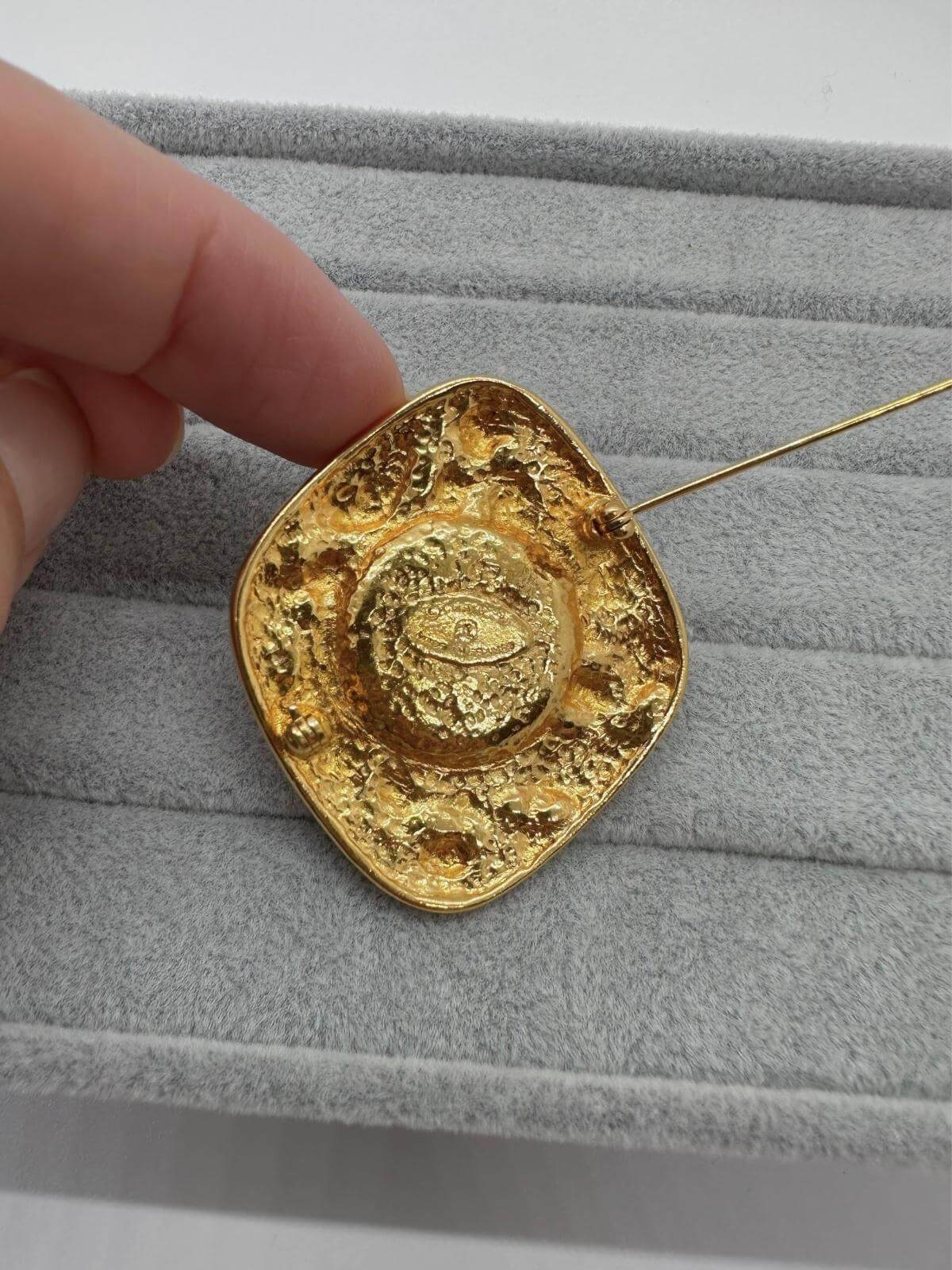 VIntage Chanel Turqoise Brooch on grey background back view of pin