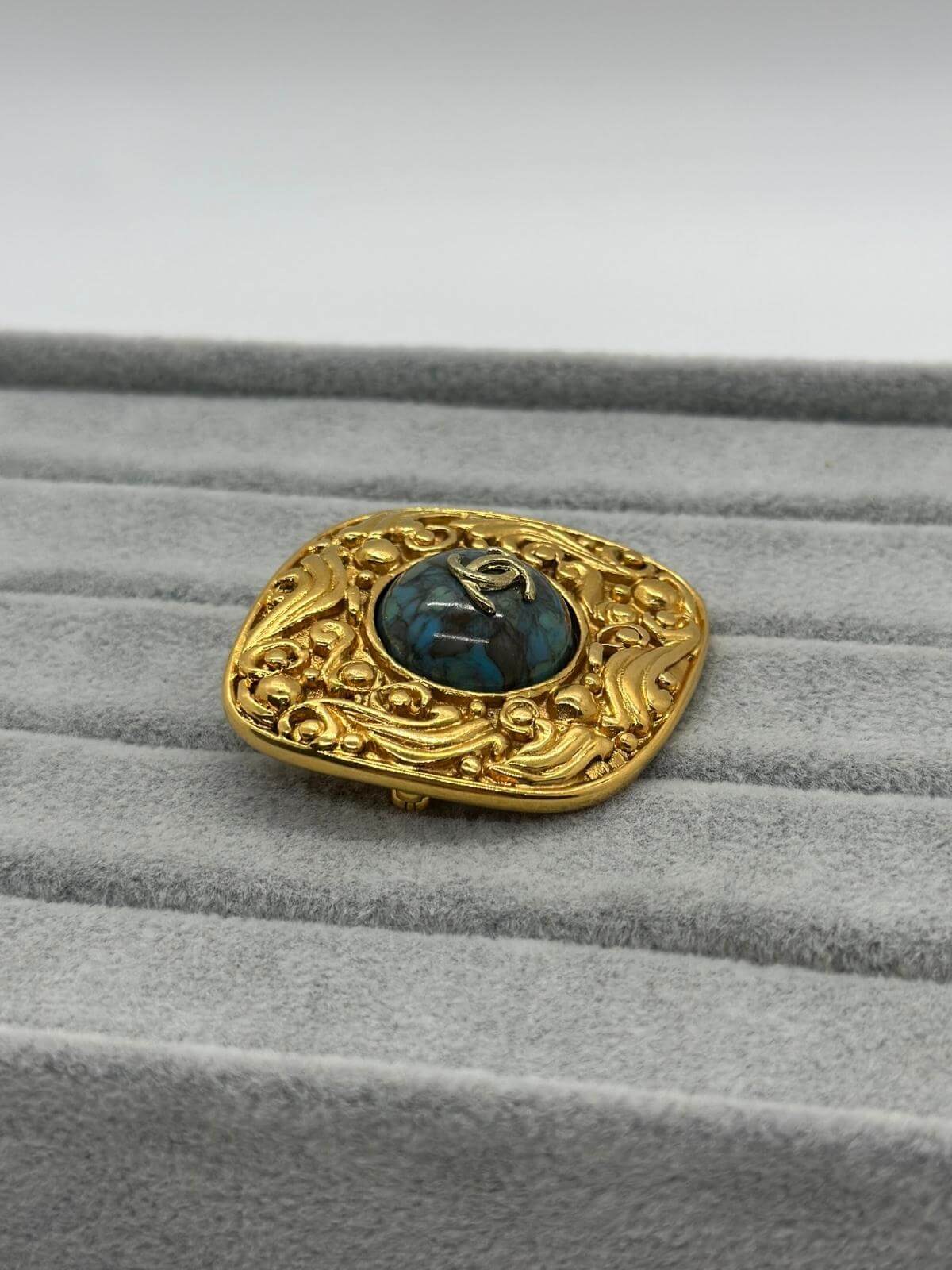 VIntage Chanel Turqoise Brooch on grey background