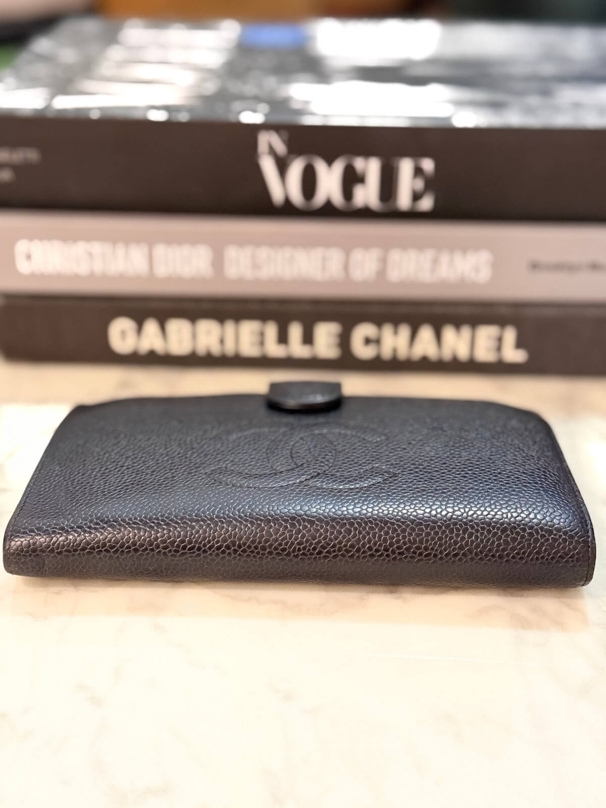 Louise Row featuring vintage Chanel black cavier embossed wallet on table 