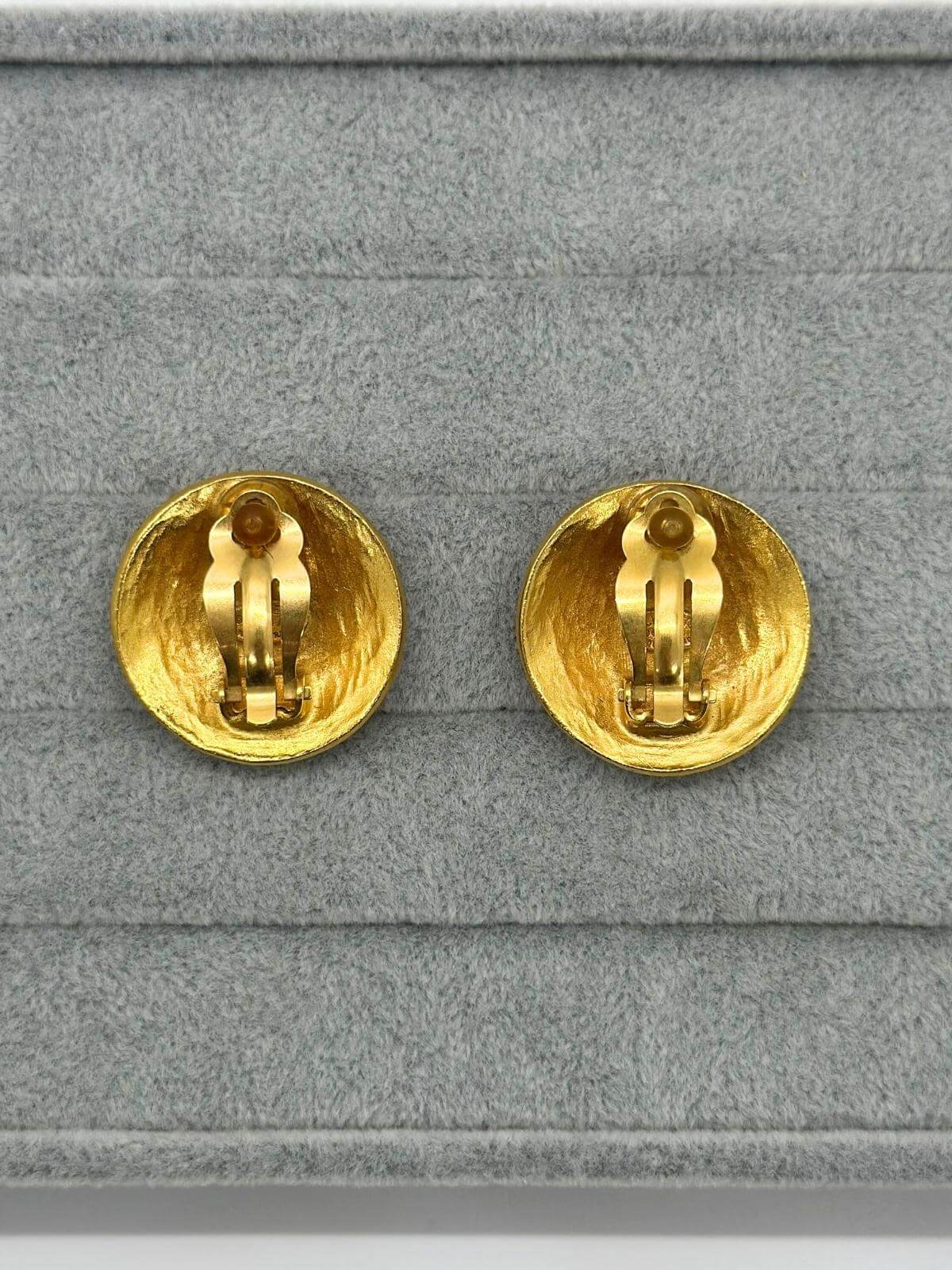 Back of Vintage Chanel gold round earring with CC logo in center on grey background. Showing clip